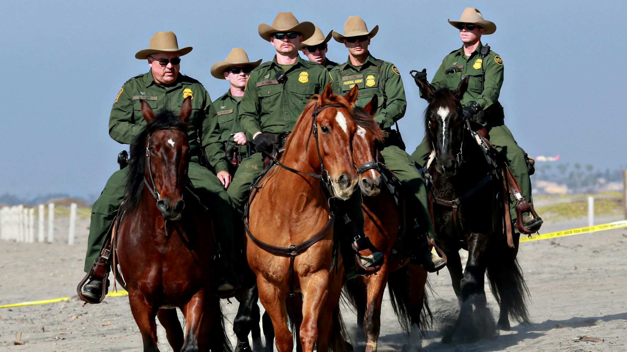 Border Patrol agents ride horses along the beach at Borderfield State Park in San Ysidro, California on November 20, 2018. - A US federal judge temporarily blocked Donald Trump's administration from denying asylum to people who enter the country illegally, prompting the president to allege Tuesday that the court was biased against him.