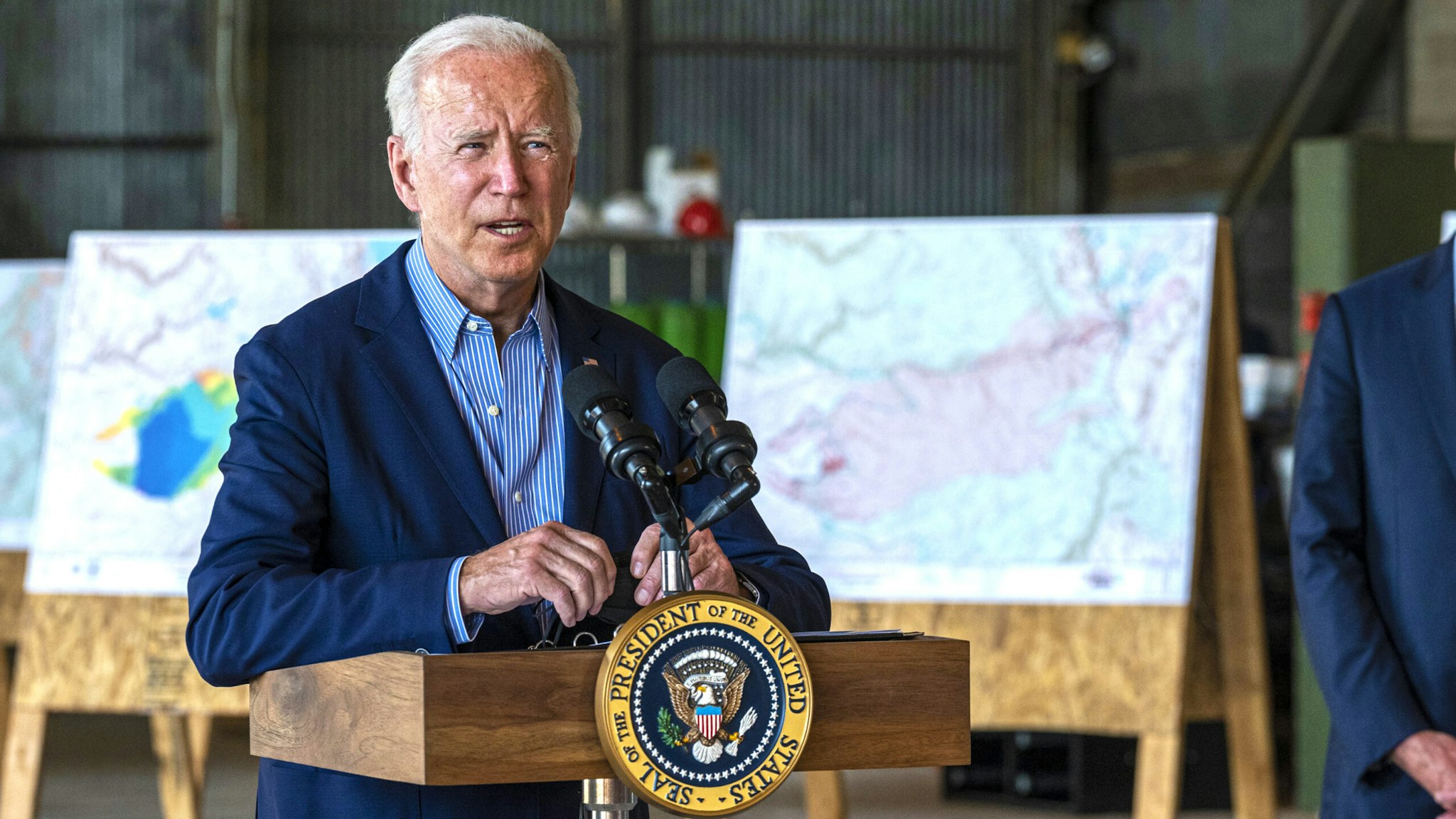U.S. President Joe Biden speaks as Gavin Newsom, governor of California, listens at Sacramento Mather Airport in Mather, California, U.S., on Monday, Sept. 13, 2021. Biden warned in California that wildfires are being supercharged by climate change and called on Congress to approve an infrastructure package that includes funding for resilience programs.