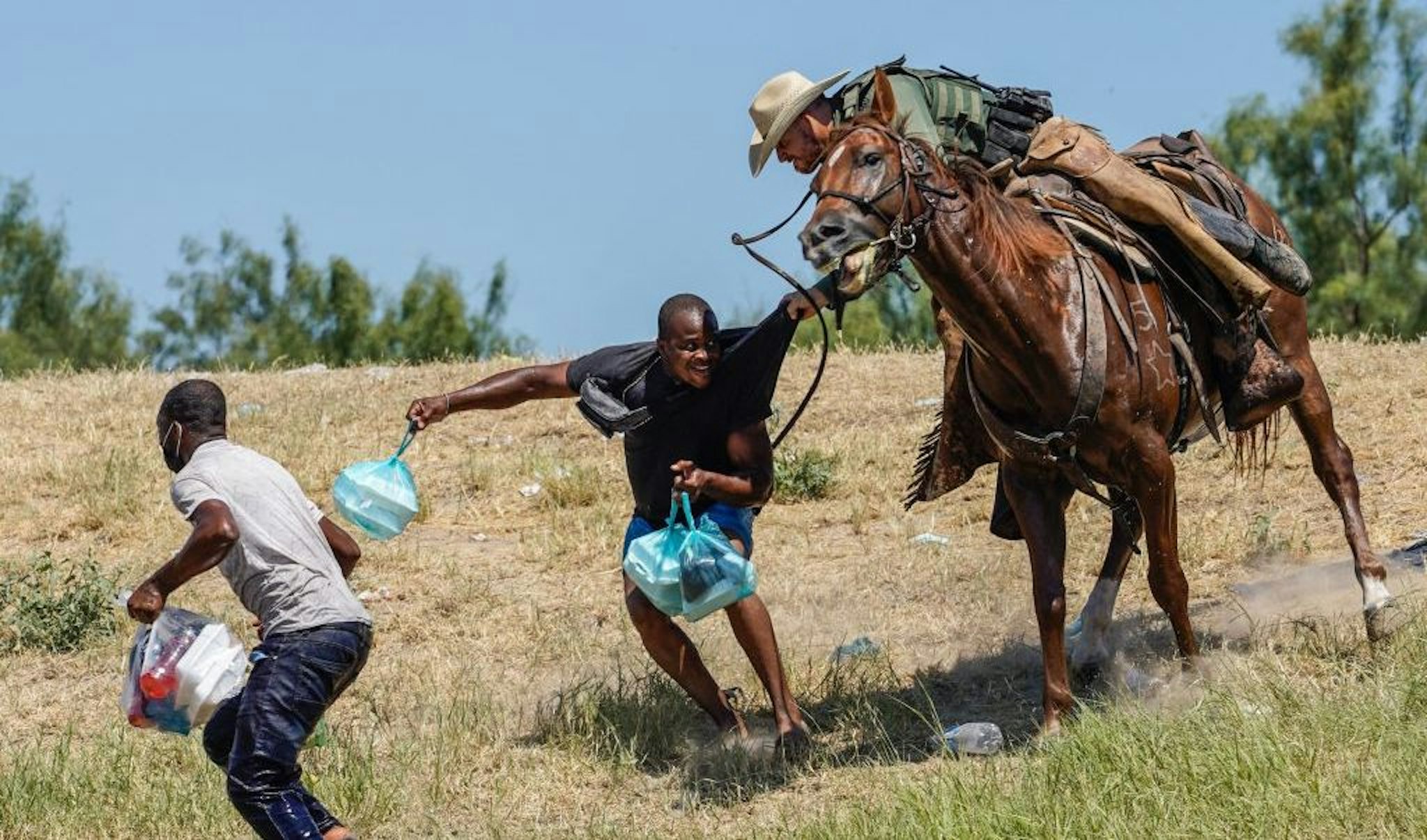 TOPSHOT - A United States Border Patrol agent on horseback tries to stop a Haitian migrant from entering an encampment on the banks of the Rio Grande near the Acuna Del Rio International Bridge in Del Rio, Texas on September 19, 2021. - The United States said Saturday it would ramp up deportation flights for thousands of migrants who flooded into the Texas border city of Del Rio, as authorities scramble to alleviate a burgeoning crisis for President Joe Biden's administration. (Photo by PAUL RATJE / AFP) (Photo by PAUL RATJE/AFP via Getty Images)