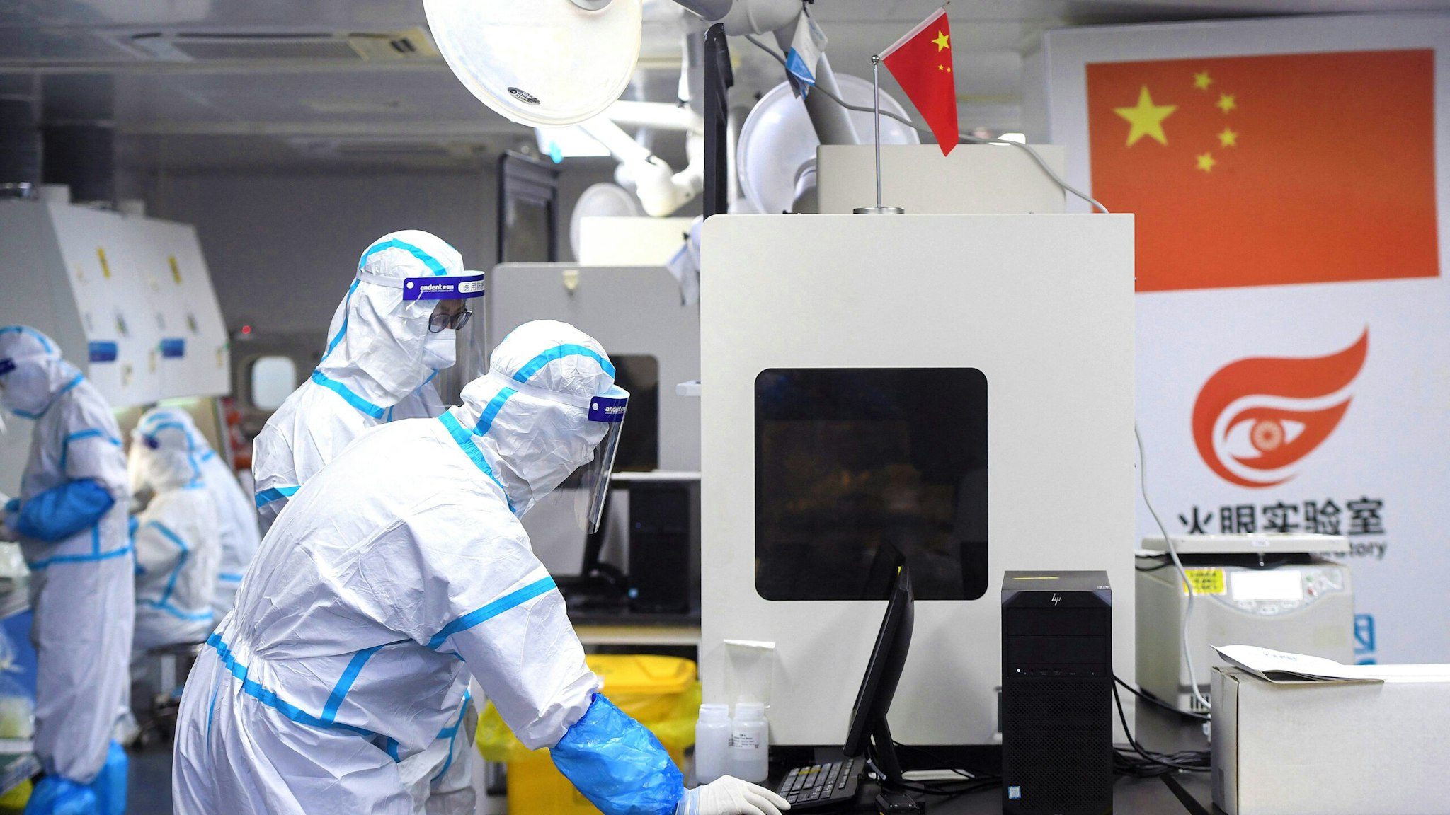 This photo taken on August 4, 2021 shows laboratory technicians wearing personal protective equipment (PPE) working on samples to be tested for the Covid-19 coronavirus at the Fire Eye laboratory, a Covid-19 testing facility, in Wuhan in China's central Hubei province. - China OUT