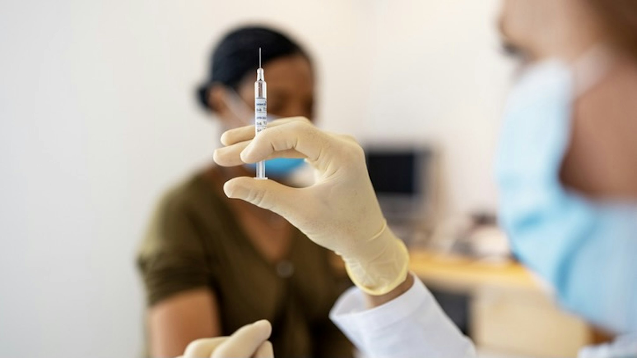 Doctor preparing flu or coronavirus injection - stock photo Close up of doctor preparing injection for vaccination in clinic. Hands of a female doctor preparing flu injection.Luis Alvarez via Getty Images