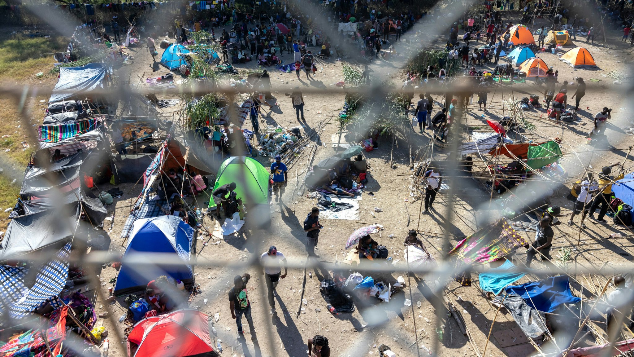 DEL RIO, TX - SEPTEMBER 17: Thousands of migrants, mostly from Haiti, gather at a makeshift encampment under the International Bridge between Del Rio, TX and Acuña, MX on September 17, 2021 in Del Rio, Texas. The makeshift encampment has grown rapidly and officials are struggling to provide food, water, shelter, and sanitation, forcing between 8,000 and 12,000 migrants to walk across the Rio Grande several times each day for basic necessities.