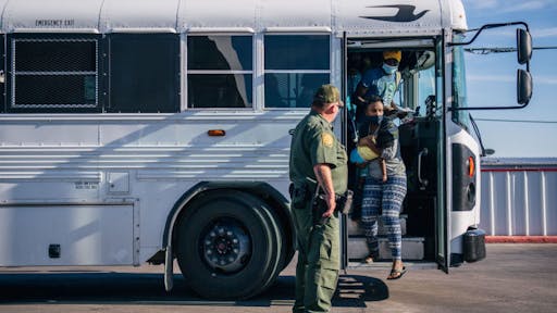 Large Migration Surge Crosses Rio Grande Into Texas DEL RIO, TEXAS - SEPTEMBER 22: Migrants exit a Border Patrol bus and prepare to be received by the Val Verde Humanitarian Coalition after crossing the Rio Grande on September 22, 2021 in Del Rio, Texas. Thousands of immigrants, mostly from Haiti, seeking asylum have crossed the Rio Grande into the United States. Families are living in makeshift tents under the international bridge while waiting to be processed into the system. U.S. immigration authorities have been deporting planeloads of migrants directly to Haiti while others have crossed the Rio Grande back into Mexico.