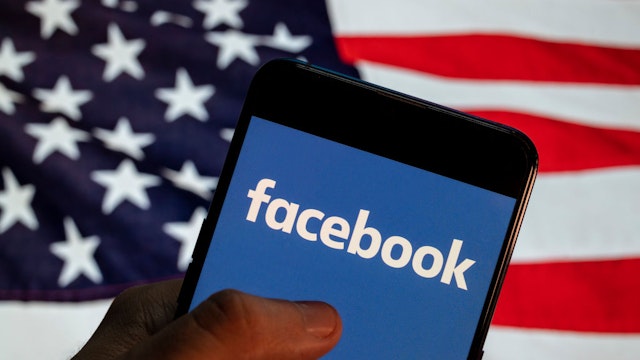 CHINA - 2021/04/02: In this photo illustration the American online social media and social networking service company Facebook (FB) logo is seen on an Android mobile device with United States of America (USA), commonly known as the United States (U.S. or US), flag in the background.