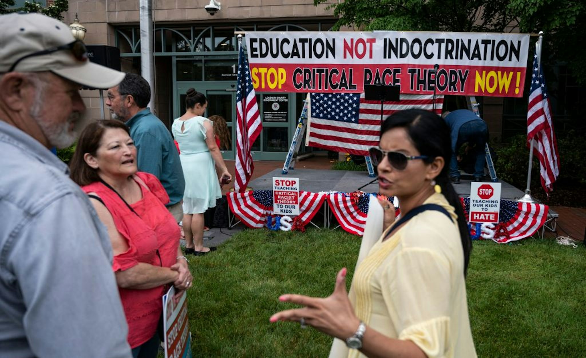 People talk before the start of a rally against "critical race theory" (CRT) being taught in schools at the Loudoun County Government center in Leesburg, Virginia on June 12, 2021.