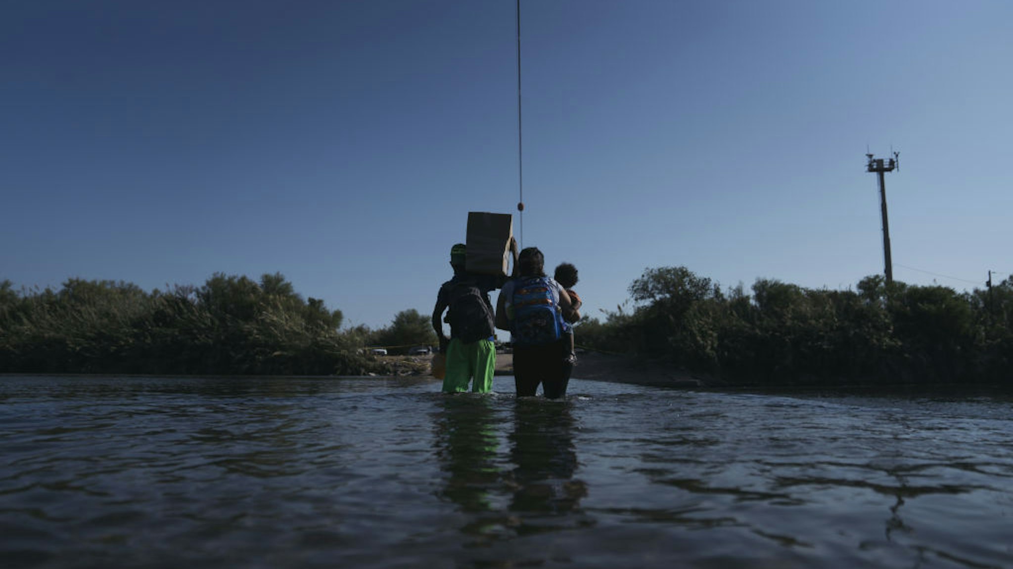 Migrants cross the Rio Grande River near the Del Rio-Acuna Port of Entry in Ciudad Acuna, Coahuila state, Mexico, on Sunday, Sept. 19, 2021. U.S. officials plan to expel Thousands of Haitian migrants that arrived at the small Texas city of Del Rio this week. Photographer: Eric Thayer/Bloomberg via Getty Images