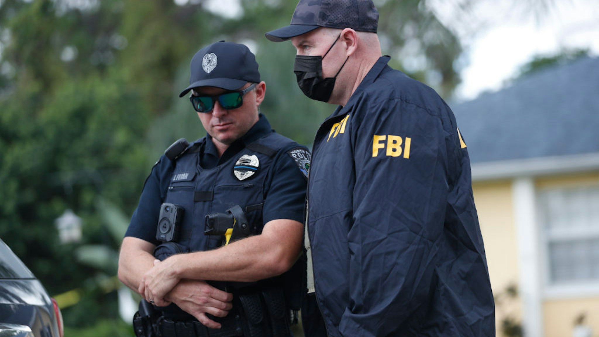 NORTH PORT, FL - SEPTEMBER 20: An FBI agent talks with a North Port officer while they collect evidence from the family home of Brian Laundrie, who is a person of interest after his fiancé Gabby Petito went missing on September 20, 2021 in North Port, Florida. A body has been found by authorities in Wyoming that fits the description of Petito, who went missing while on a cross country trip with Laundrie. (Photo by Octavio Jones/Getty Images)