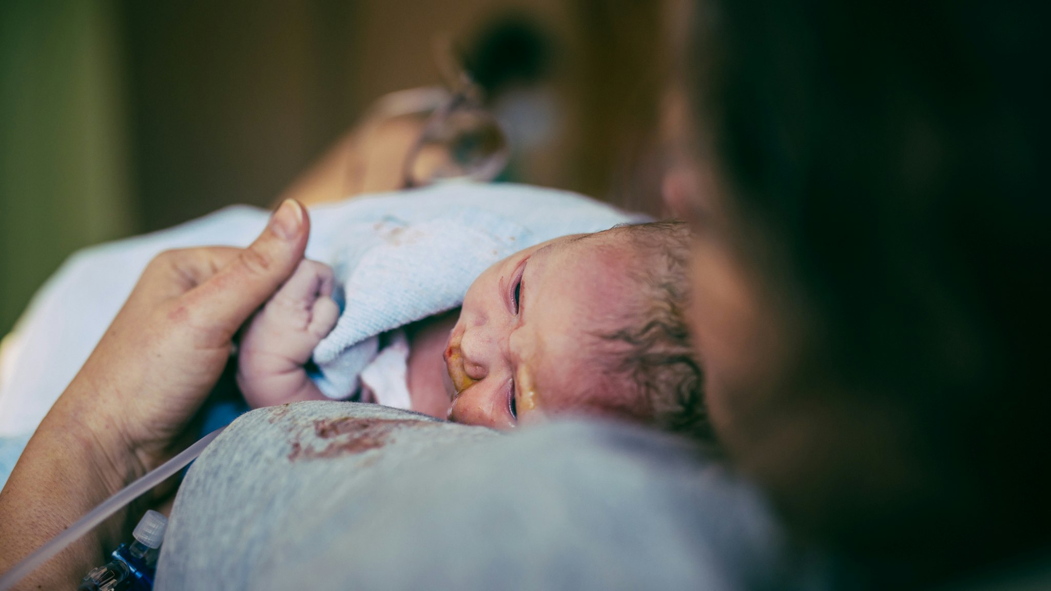 Woman holding her newborn after birth in hospital. - stock photo