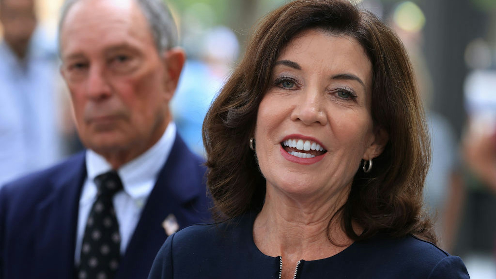 New York Gov. Kathy Hochul (R) and former New York City Mayor Mike Bloomberg talk to reporters after laying flowers at the south memorial pool to commemorate the 20th anniversary of the September 11 terror attack at the 9/11 Memorial and Museum on September 08, 2021 in New York City.