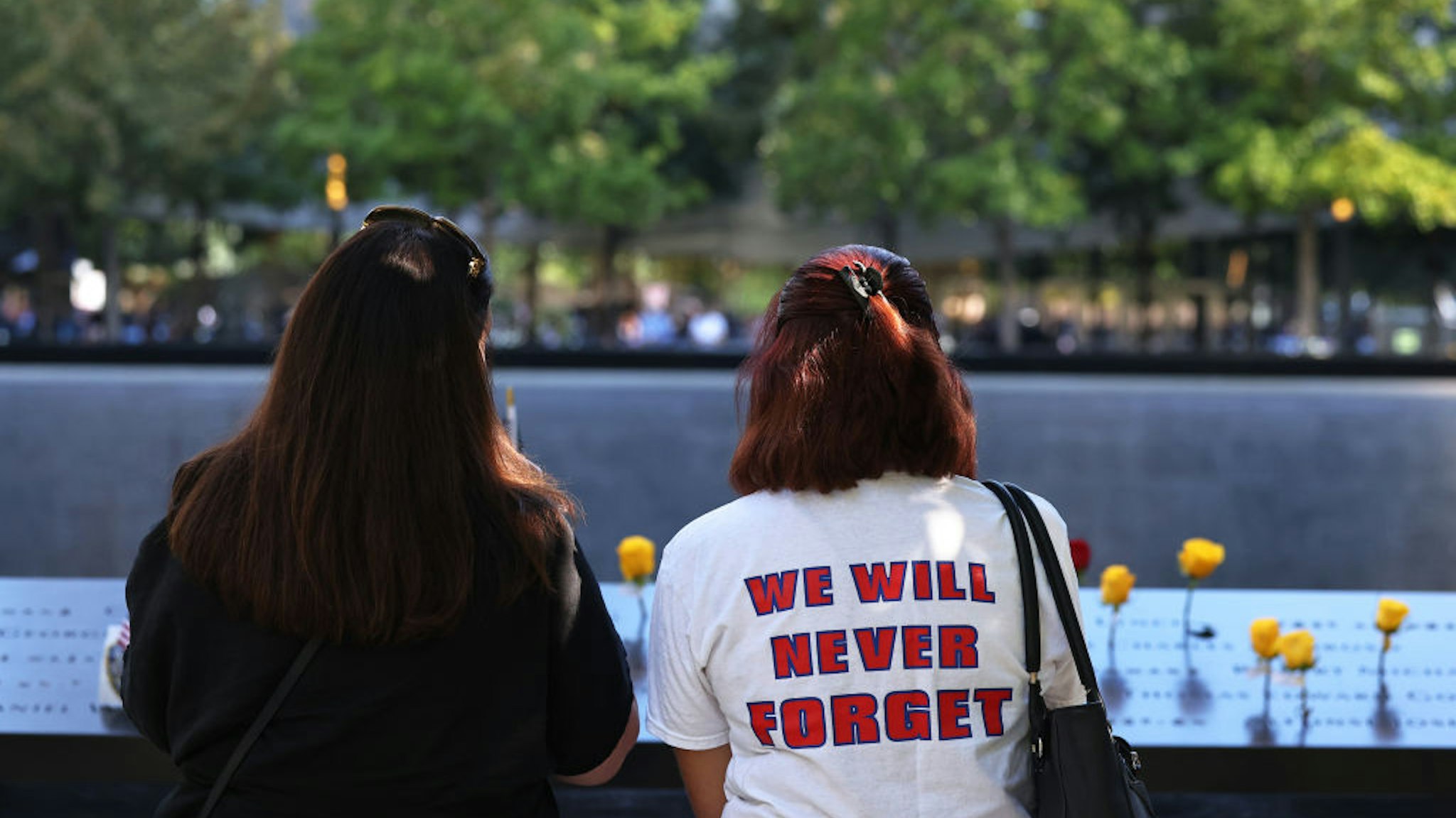 People attend the annual 9/11 Commemoration Ceremony at the National 9/11 Memorial and Museum on September 11, 2021 in New York City. During the ceremony, six moments of silence were held, marking when each of the World Trade Center towers was struck and fell and the times corresponding to the attack on the Pentagon and the crash of Flight 93.