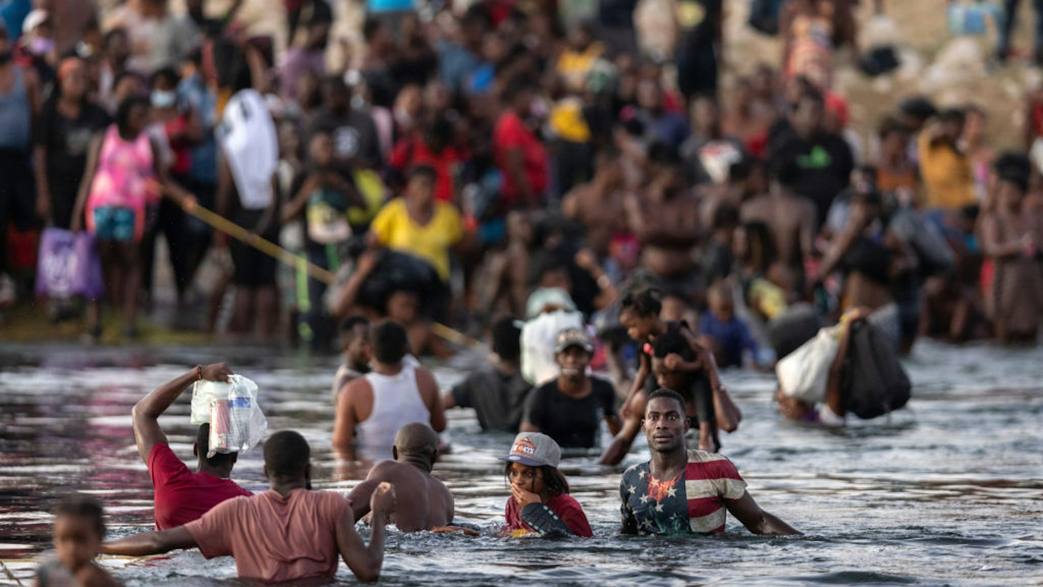 mmigrants, mostly from Haiti gather on the bank of the Rio Grande on September 19, 2021 in Ciudad Acuna, Mexico, across the border from Del Rio, Texas. A