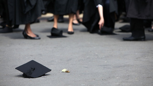 BIRMINGHAM, ENGLAND - JULY 14: Students pick up their mortarboards after the offical hat throwing photograph at the University of Birmingham on July 14, 2009 in Birmingham, England. Over 5000 graduates will be donning their robes this week to collect their degrees from The University of Birmingham. A recent survey suggested that there are 48 graduates competing for every job. (Photo by Christopher Furlong/Getty Images)