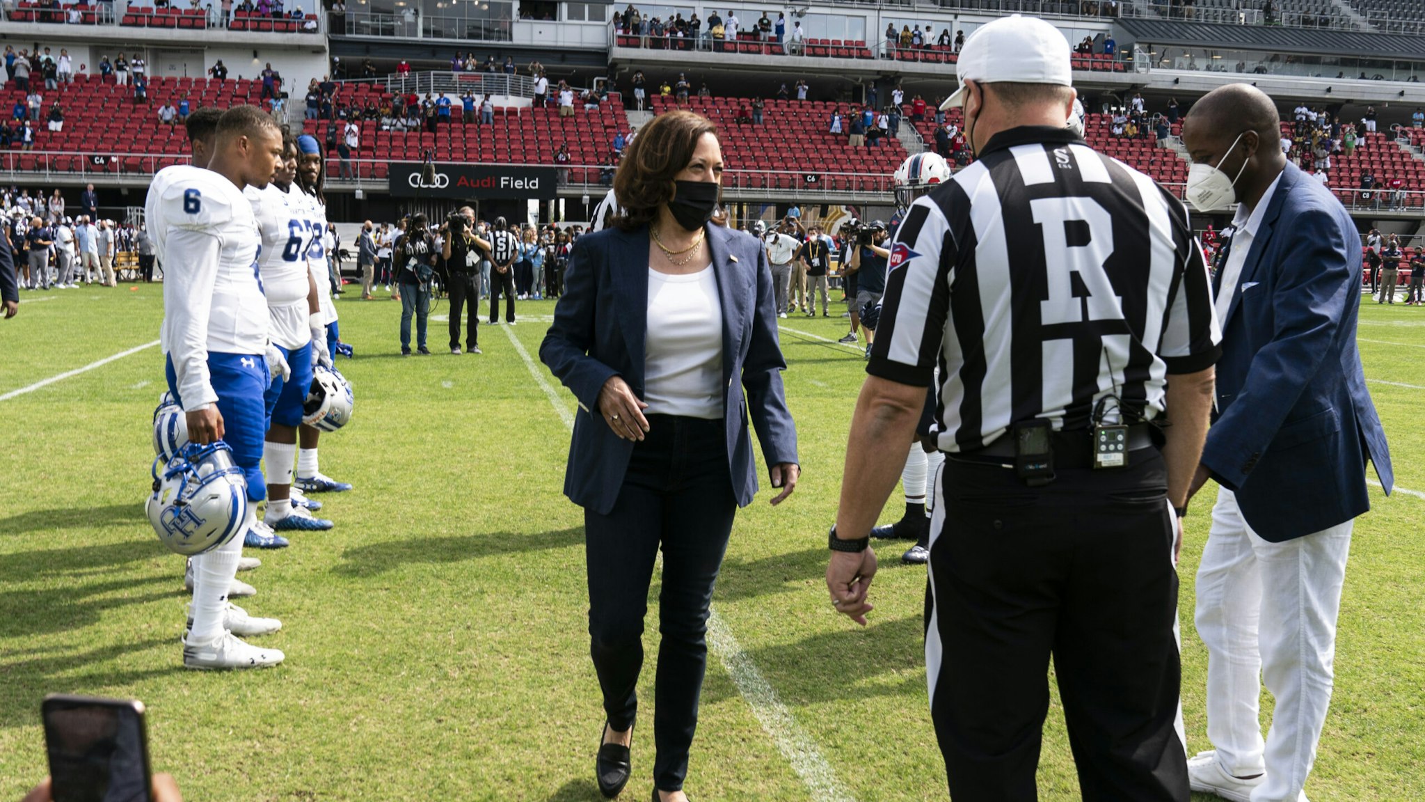U.S. Vice President Kamala Harris, center, arrives to flip a coin ahead of the Howard University and Hampton University football game at Audi Field in Washington, D.C., U.S., on Saturday, Sept. 18, 2021. The two teams, both historically Black universities, are playing the first-ever Truth and Service Classic game hosted in partnership with Events DC.