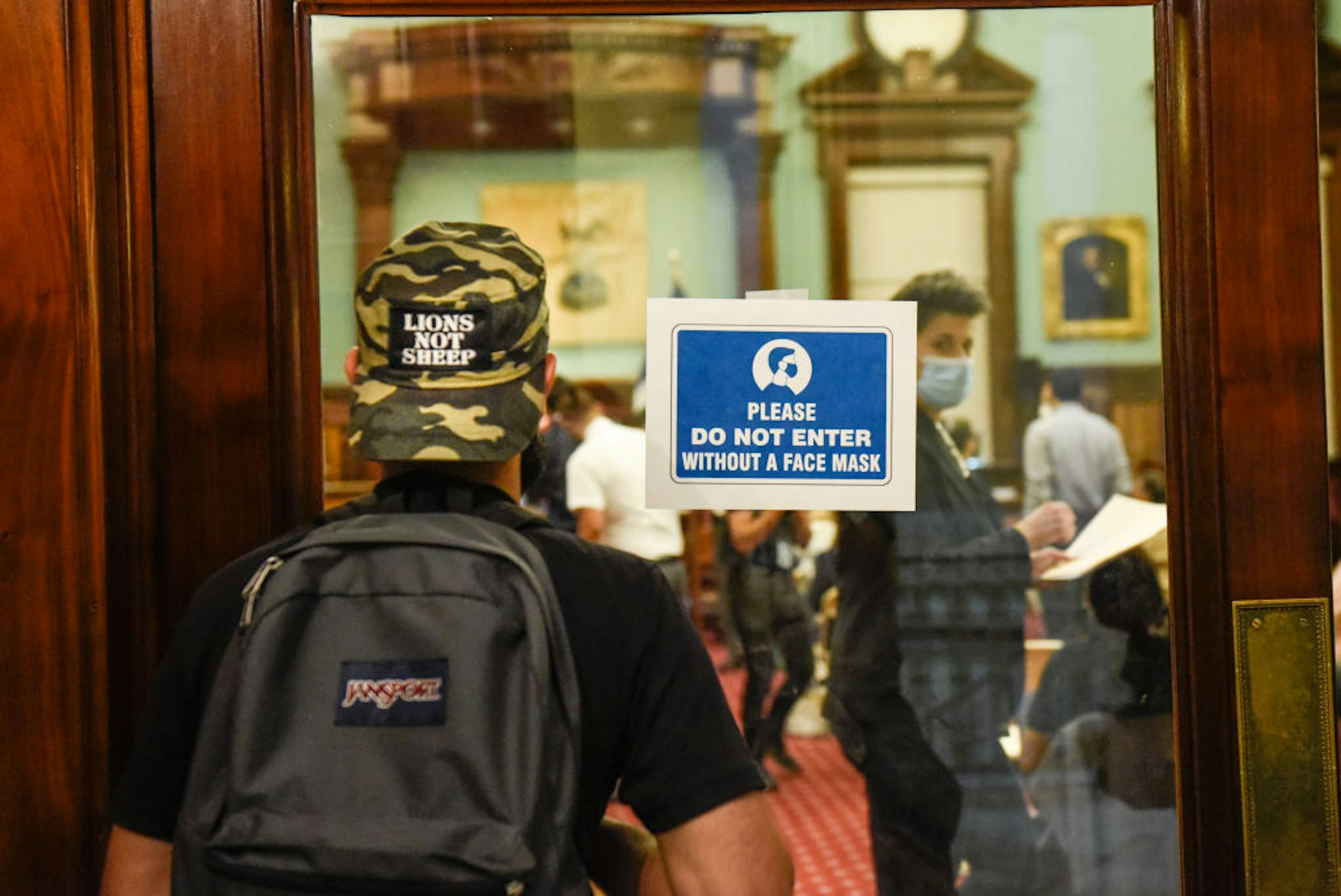 A visitor tries to enter without wearing a protective during a New York City Council hearing on Mayor Bill de Blasio's back-to-school plans in New York, U.S., on Wednesday, Sept. 1, 2021. New York City Council members confronted Mayor Bill de Blasio's top school and health officials Wednesday with concerns raised by educators and parents who say the citys back-to-school preparations remain fraught with uncertainty. 
