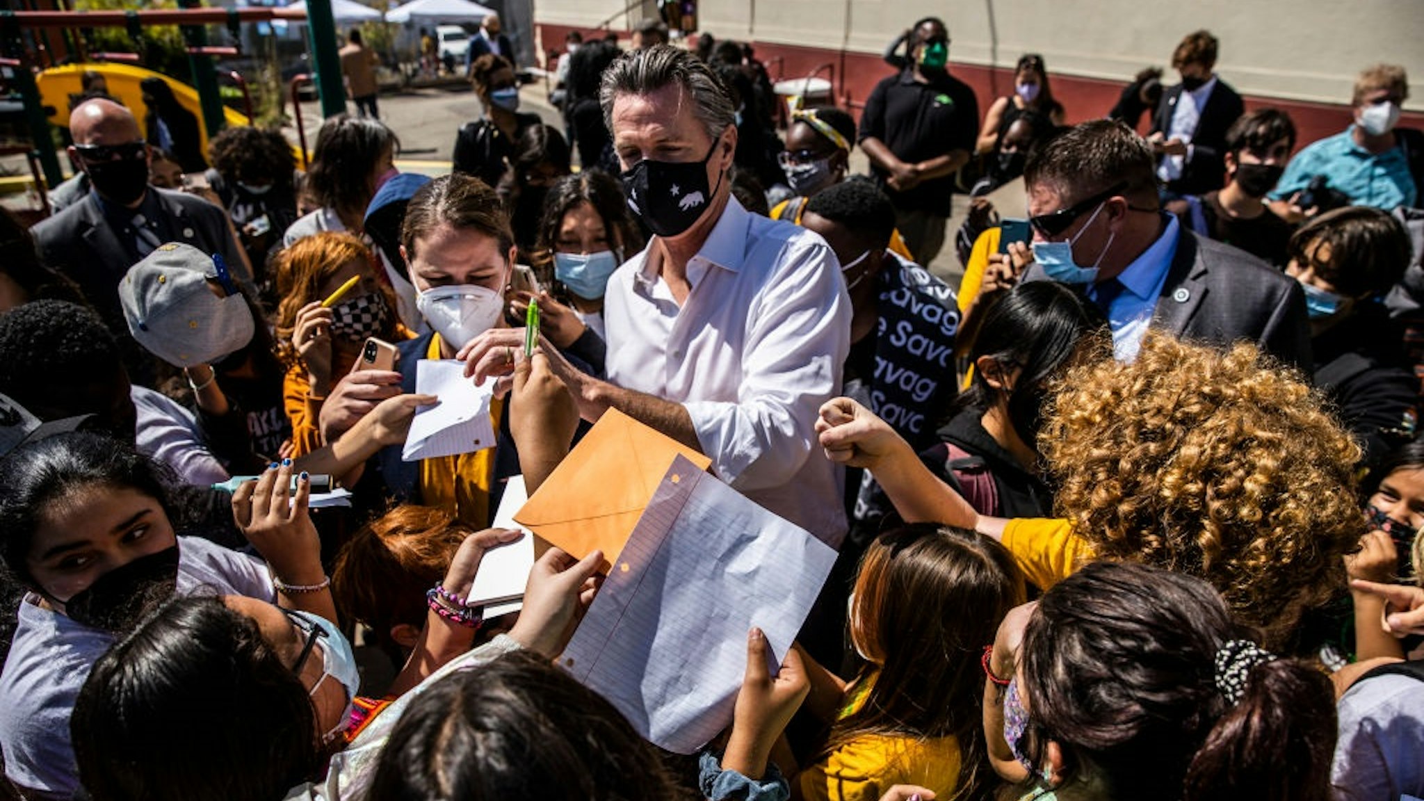 SAN FRANCISCO, CA - SEPTEMBER 15: California Governor Gavin Newsom signs autographs for students during a visit at Melrose Leadership Academy the day after surviving the gubernatorial recall election in Oakland, California on Wednesday, Sept. 15, 2021.