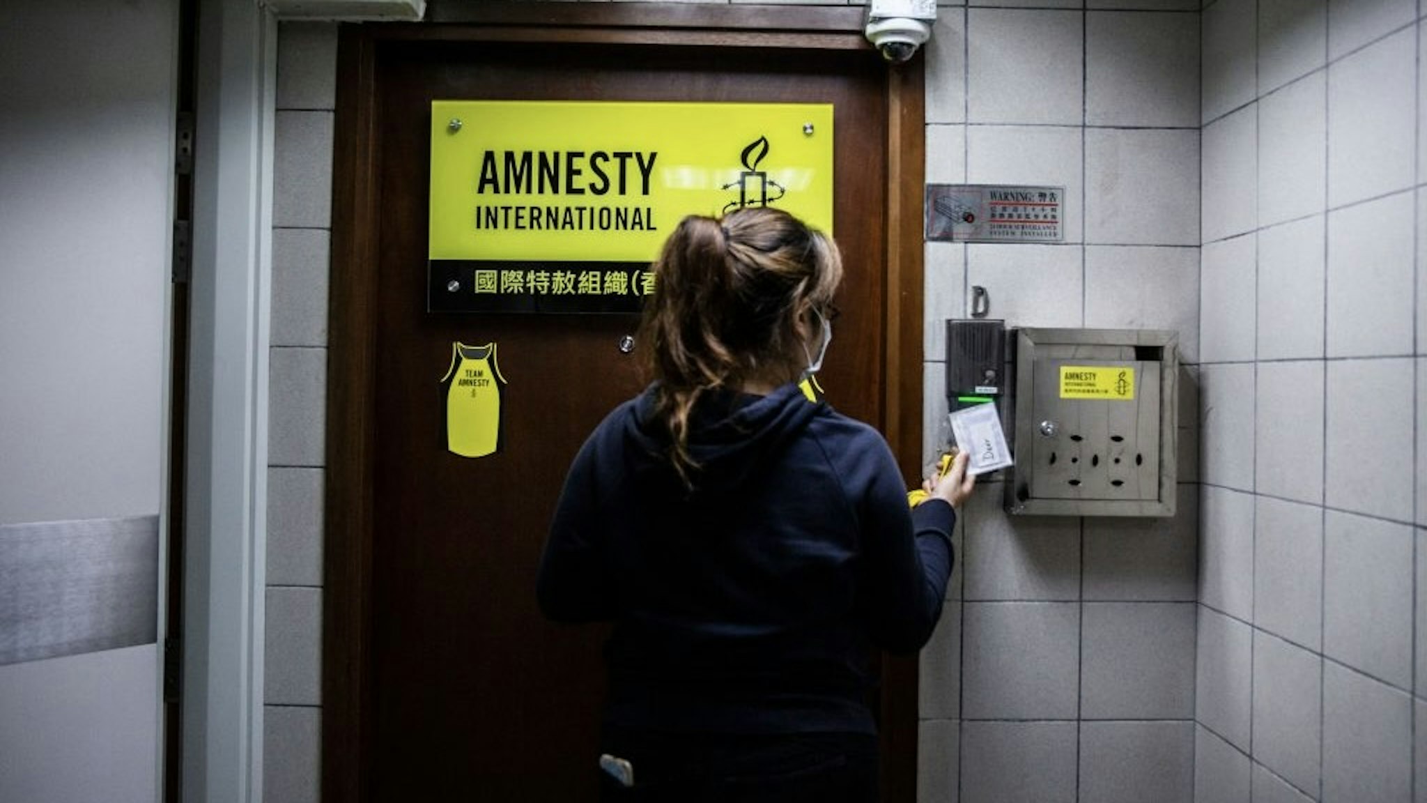 HONG KONG-CHINA-POLITICS-RIGHTS-AMNESTY A woman is seen at the entrance to Amnesty International offices in Hong Kong on October, 2021, as the Human Rights organisation announces it will be closing its offices by the end of 2021 citing Beijings enacted national security law as a reason. (Photo by ISAAC LAWRENCE / AFP) (Photo by ISAAC LAWRENCE/AFP via Getty Images) ISAAC LAWRENCE / Contributor