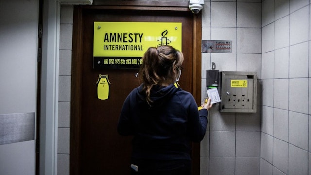 HONG KONG-CHINA-POLITICS-RIGHTS-AMNESTY A woman is seen at the entrance to Amnesty International offices in Hong Kong on October, 2021, as the Human Rights organisation announces it will be closing its offices by the end of 2021 citing Beijings enacted national security law as a reason. (Photo by ISAAC LAWRENCE / AFP) (Photo by ISAAC LAWRENCE/AFP via Getty Images) ISAAC LAWRENCE / Contributor