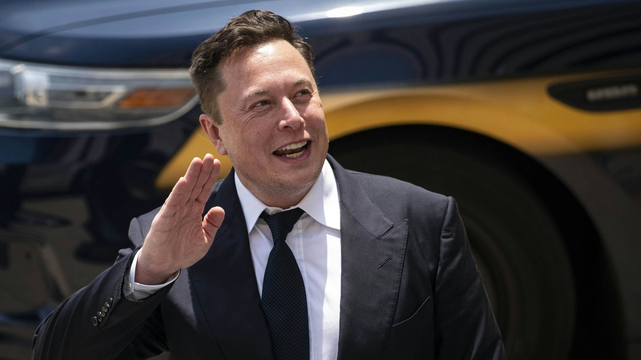 Elon Musk, chief executive officer of Tesla Inc., waves while departing court during the SolarCity trial in Wilmington, Delaware, U.S., on Tuesday, July 13, 2021. Musk was cool but combative as he testified in a Delaware courtroom that Tesla's more than $2 billion acquisition of SolarCity in 2016 wasn't a bailout of the struggling solar provider.