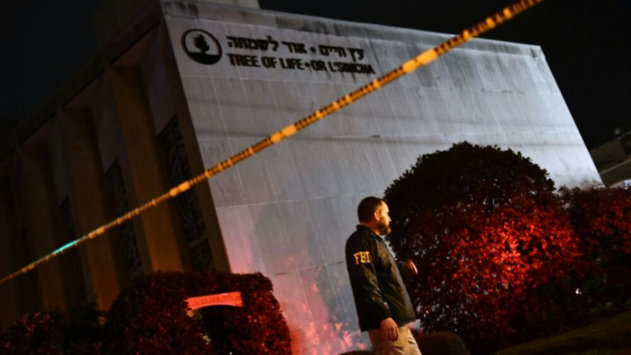TOPSHOT - An FBI agent stands behind a police cordon outside the Tree of Life Synagogue after a shooting there left 11 people dead in the Squirrel Hill neighborhood of Pittsburgh on October 27, 2018. - A heavily armed gunman opened fire during a baby-naming ceremony at a synagogue in the US city of Pittsburgh on October 27, killing 11 people and injuring six in the deadliest anti-Semitic attack in recent American history.
