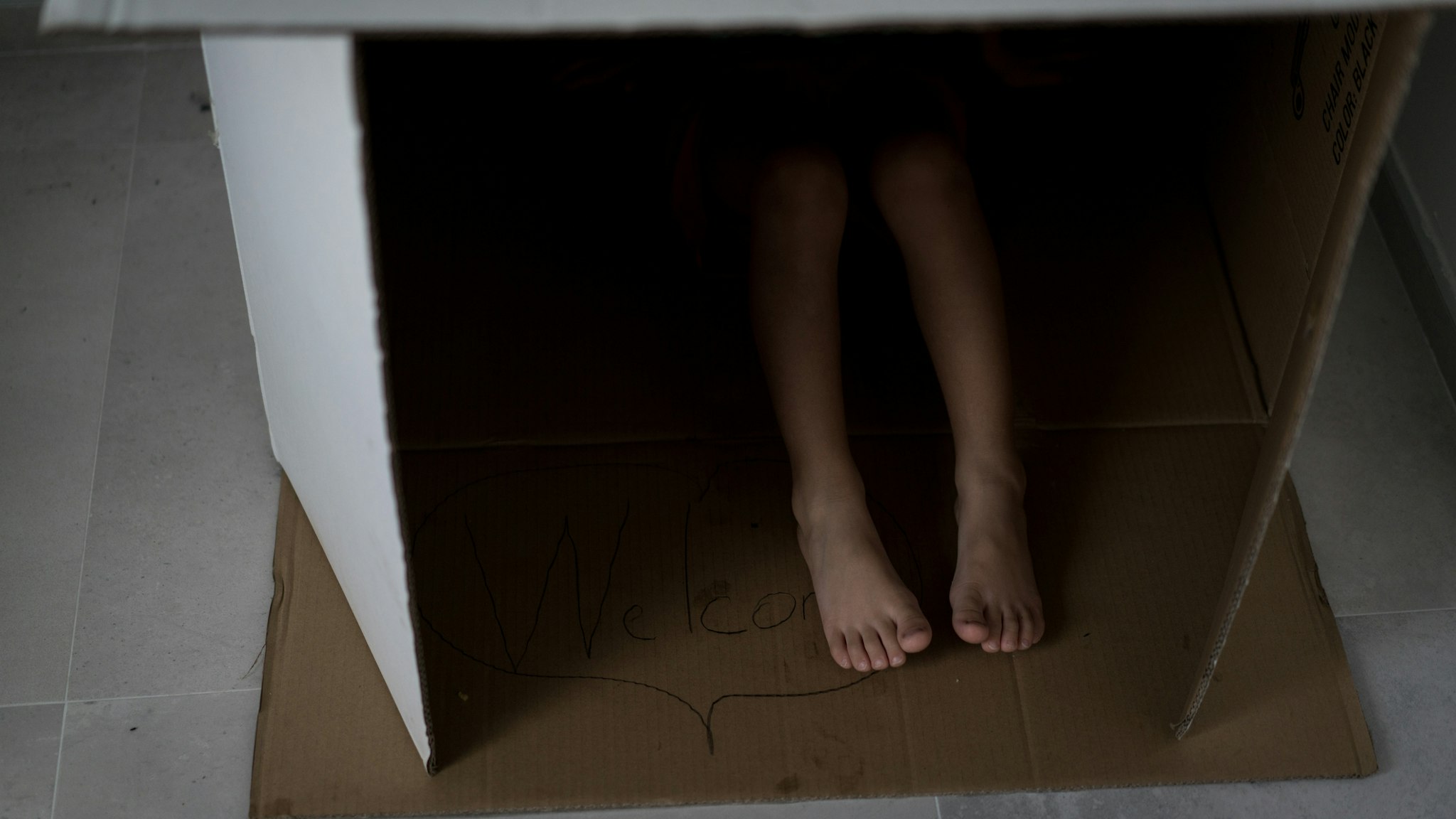 Child feet in carton box - stock photo