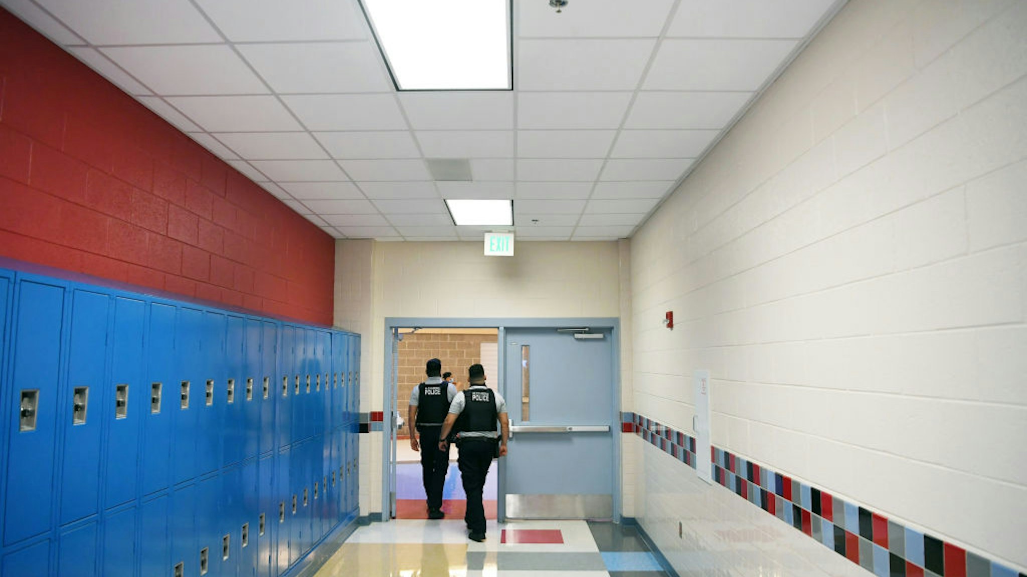 Alexandria Police Department school resource officers, Johnny Larios, left center, and Gary Argueta, right center, walk through a hallway at T.C. Williams High School on Wednesday June 09, 2021 in Alexandria, VA.