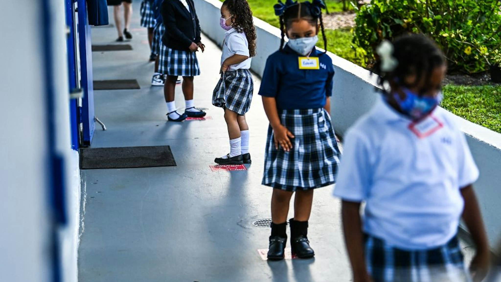 Students wear facemasks and stand in a social distance on their first day of school after summer vacation at the St. Lawrence Catholic School in north of Miami, on August 18, 2021. (Photo by CHANDAN KHANNA / AFP) (Photo by CHANDAN KHANNA/AFP via Getty Images)