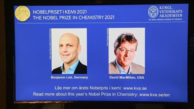 A screen displays the co-winners of the 2021 Nobel Prize in Chemistry, Germany's Benjamin List (L) and David MacMillan of the United States, during a press conference at the Royal Swedish Academy of Sciences in Stockholm, Sweden, on October 6, 2021. - Germany's Benjamin List and David MacMillan of the United States on October 6, 2021 won the Nobel Prize in Chemistry for their development of a precise new tool for molecular construction, the jury said. The duo was awarded "for their development of a precise new tool for molecular construction: organocatalysis. This has had a great impact on pharmaceutical research, and has made chemistry greener," the Nobel Committee said.