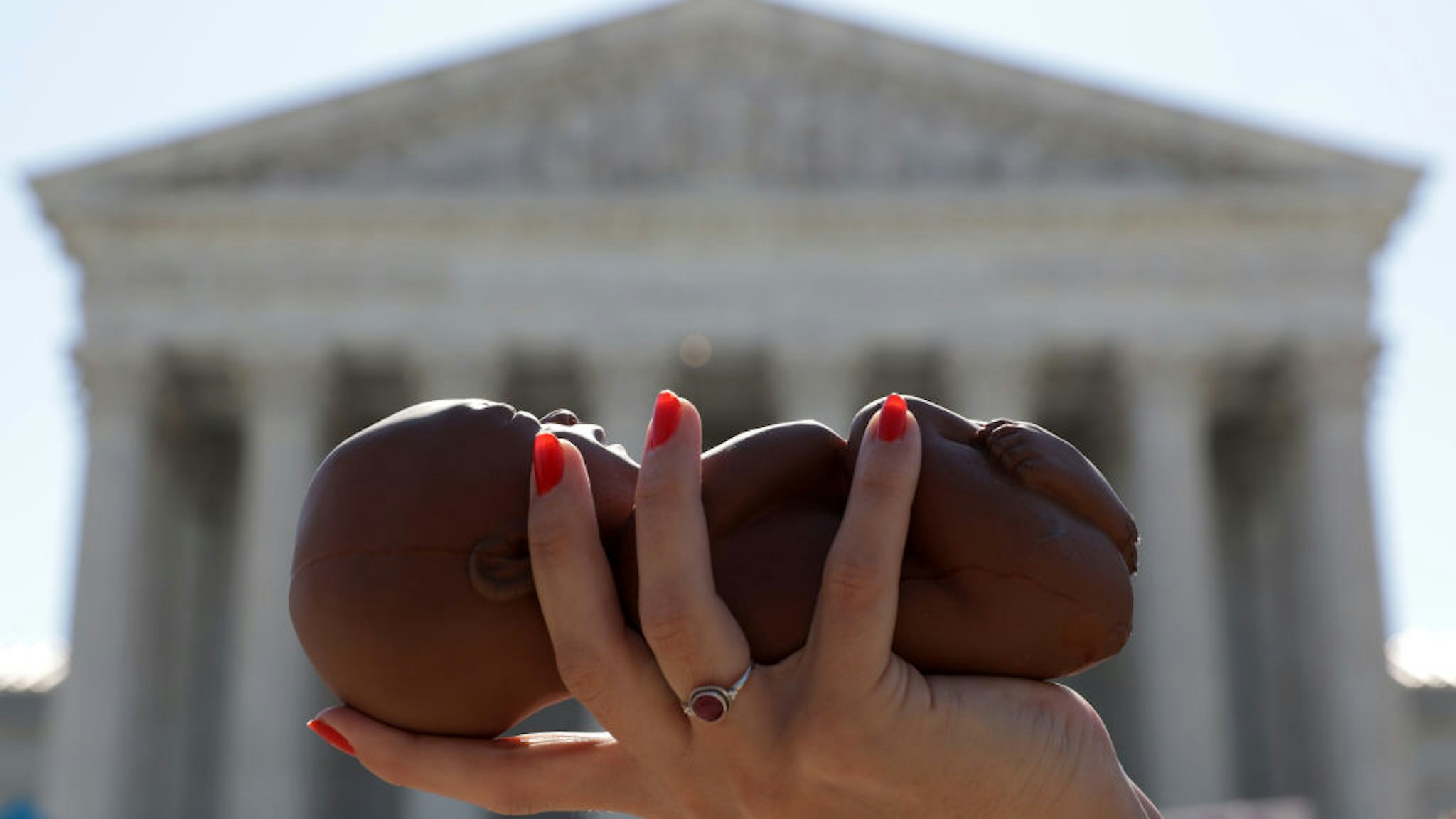 WASHINGTON, DC - JUNE 29: A pro-life activist holds a model fetus during a demonstration in front of the U.S. Supreme Court June 29, 2020 in Washington, DC. The Supreme Court has ruled today, in a 5-4 decision, a Louisiana law that required abortion doctors need admitting privileges to nearby hospitals unconstitutional. (Photo by Alex Wong/Getty Images)