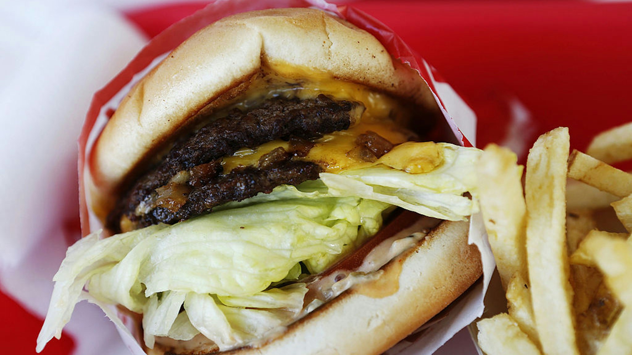 In-N-Out Burger's signature Double-Double cheeseburger and french fries are arranged for a photograph at a restaurant in Costa Mesa, California, U.S., on Wednesday, Feb. 6, 2013.