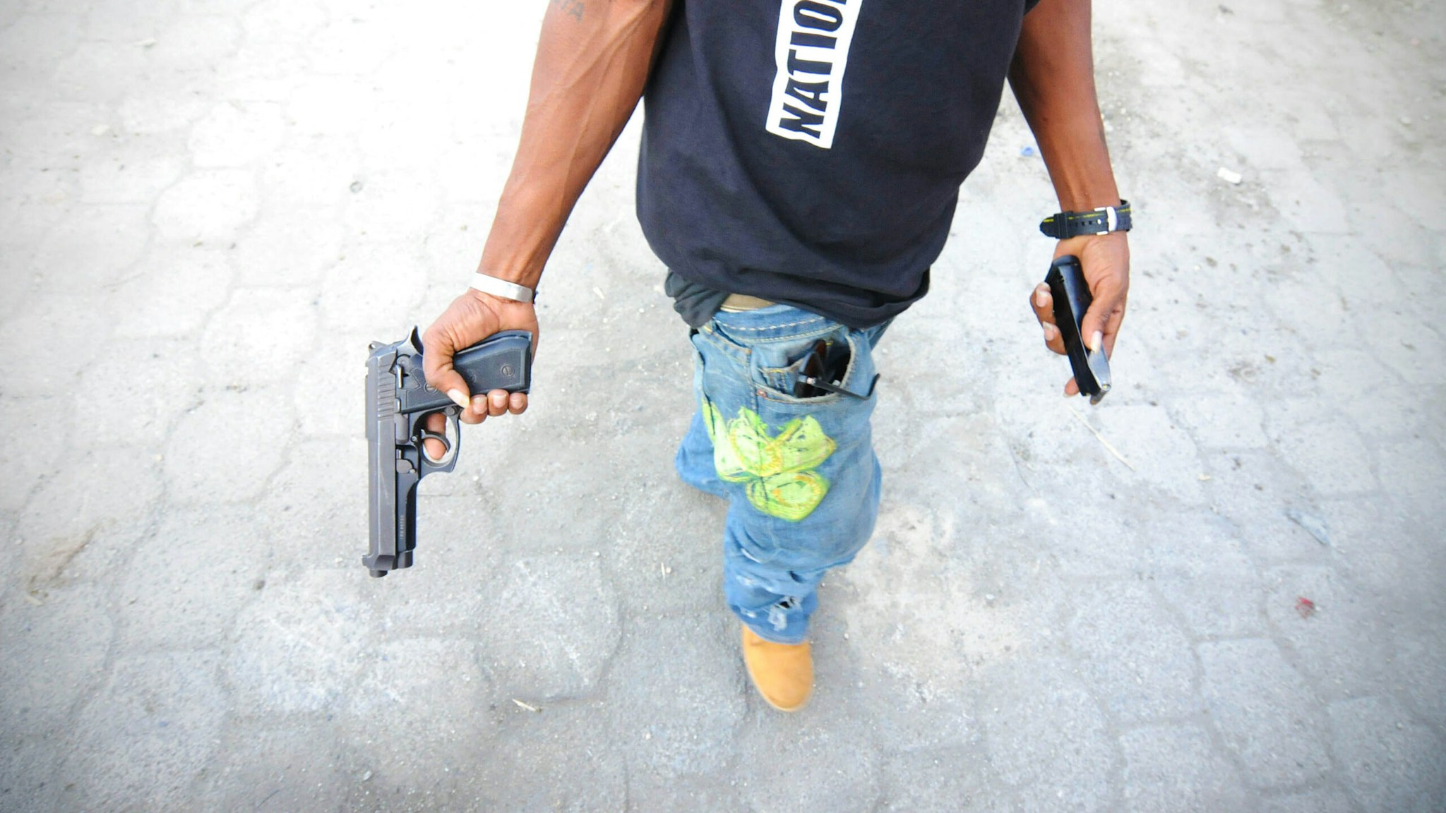 (GERMANY OUT) Port-au-Prince, Haiti. The slum Cite Soleil is known to be the battleground between gangs who settle scores and against UN troops who have on numerous occasions tried to pacify the area. A gang member connected with the LP Street gang is arming his pistol.