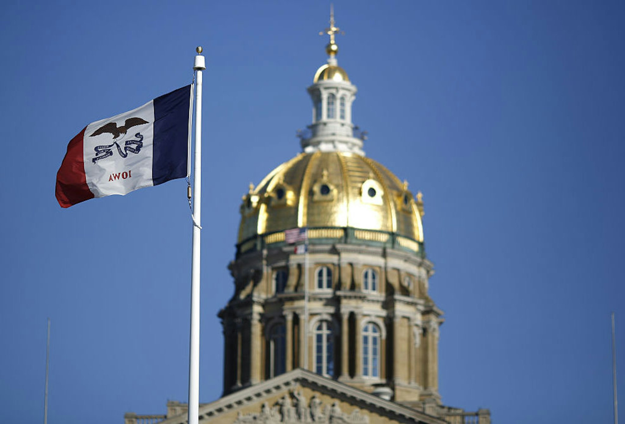 The Iowa state flag flies outside the State Capitol Building in Des Moines, Iowa, U.S., on Friday, Jan. 29, 2016. As the first in the nation Iowa caucuses approaches, where registering your vote isn't as simple as casting a ballot, the state is starting to thrum with nervous energy.