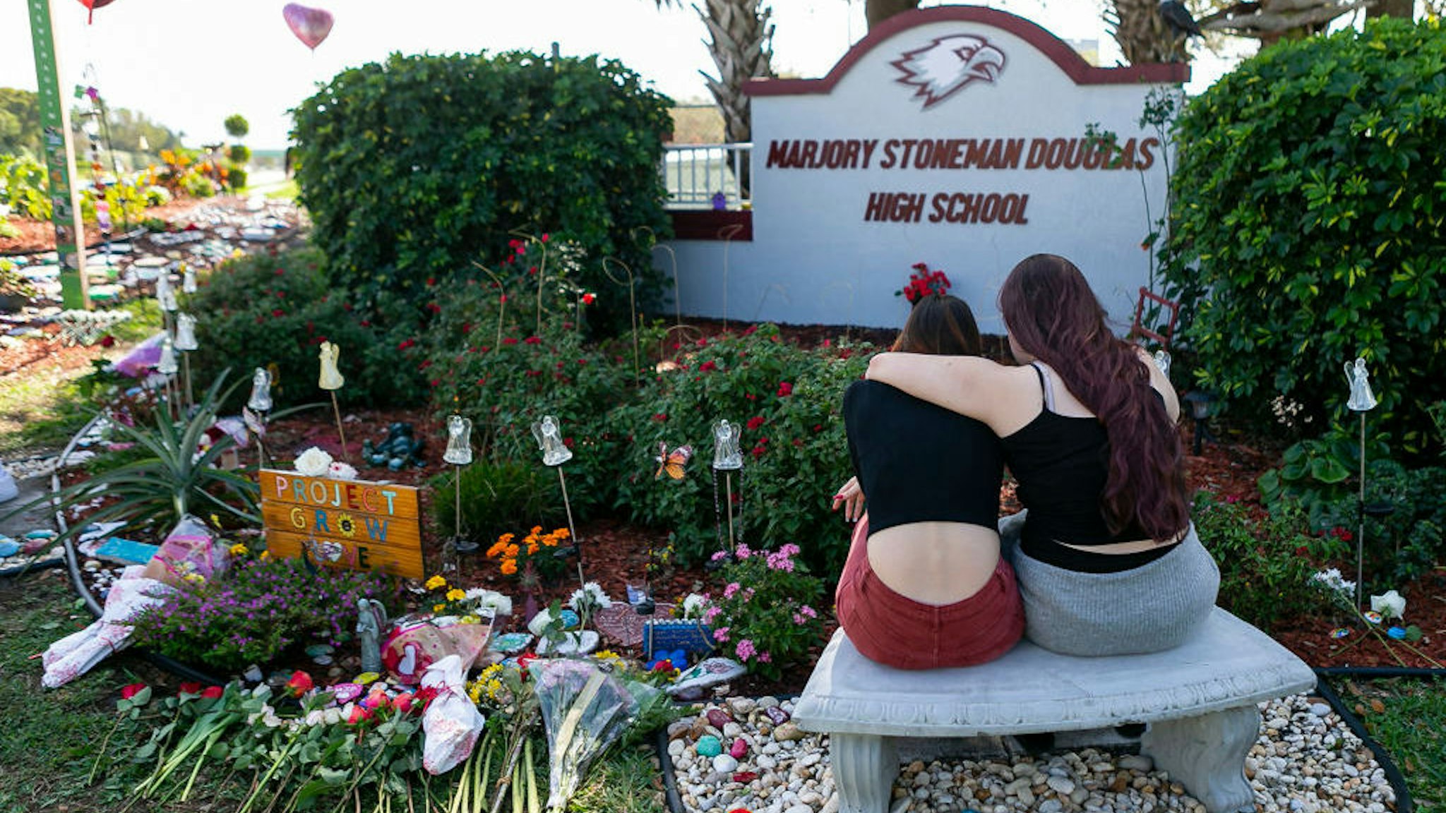 Jess Shanahan, 17, puts her arm around her friend, Lauryn Augustyne, 19, as they visit a makeshift memorial outside of Marjory Stoneman Douglas High School in Parkland, Fla., on Friday, Feb. 14, 2020, during the two-year anniversary of the Parkland shooting where 17 victims were killed. (Matias J. Ocner/Miami Herald/TNS)