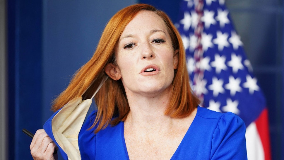 White House Press Secretary Jen Psaki takes off her mask as she arrives for the daily briefing in the Brady Briefing Room of the White House in Washington, DC on October 1, 2021.