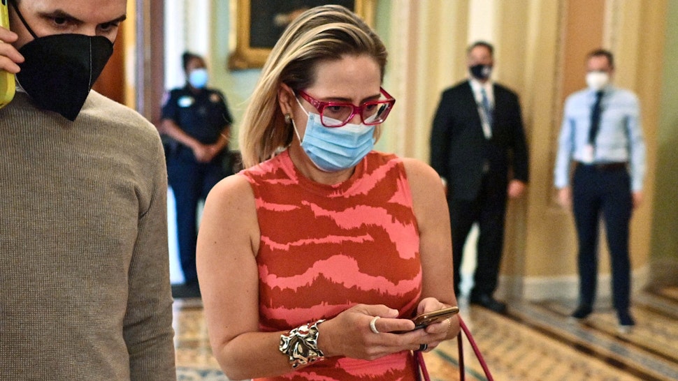 US Senator Kyrsten Sinema (D-AZ) walks through the Senate at the US Capitol in Washington, DC on September 30, 2021. - US lawmakers were set to approve a stopgap funding bill Thursday to avert a crippling government shutdown as Democratic leaders struggle to get their members in line behind President Joe Biden's agenda.