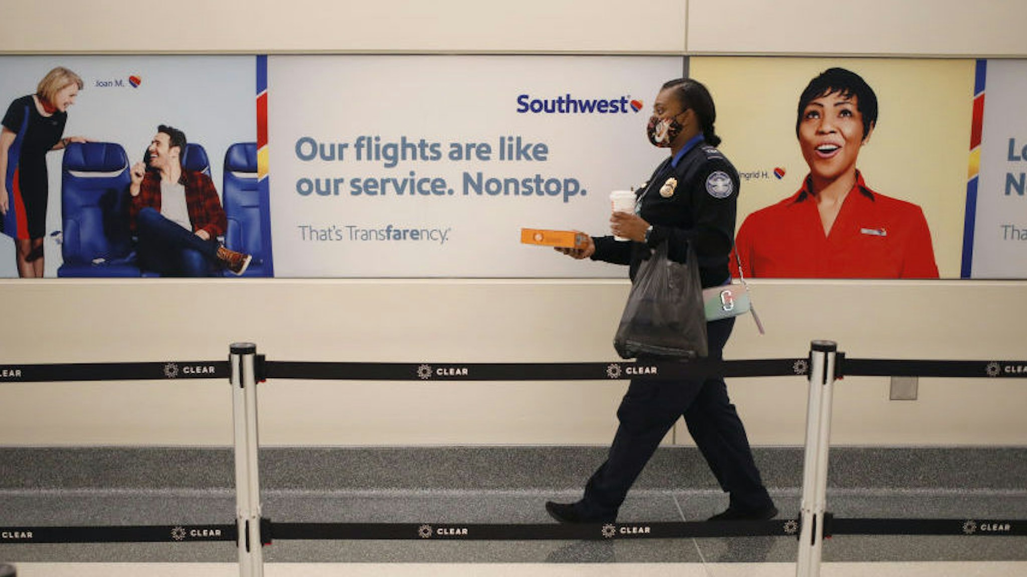 A Transportation Security Administration (TSA) officer walks past Southwest Airlines Co. signage at Midway International Airport (MDW) in Chicago, Illinois, U.S., on Monday, Oct. 11, 2021. Southwest Airlines Co. disruptions moved into a fourth day, with 355 canceled flights, or 10% of its daily schedule, on Monday, the latest in a series of setbacks at the carrier. 