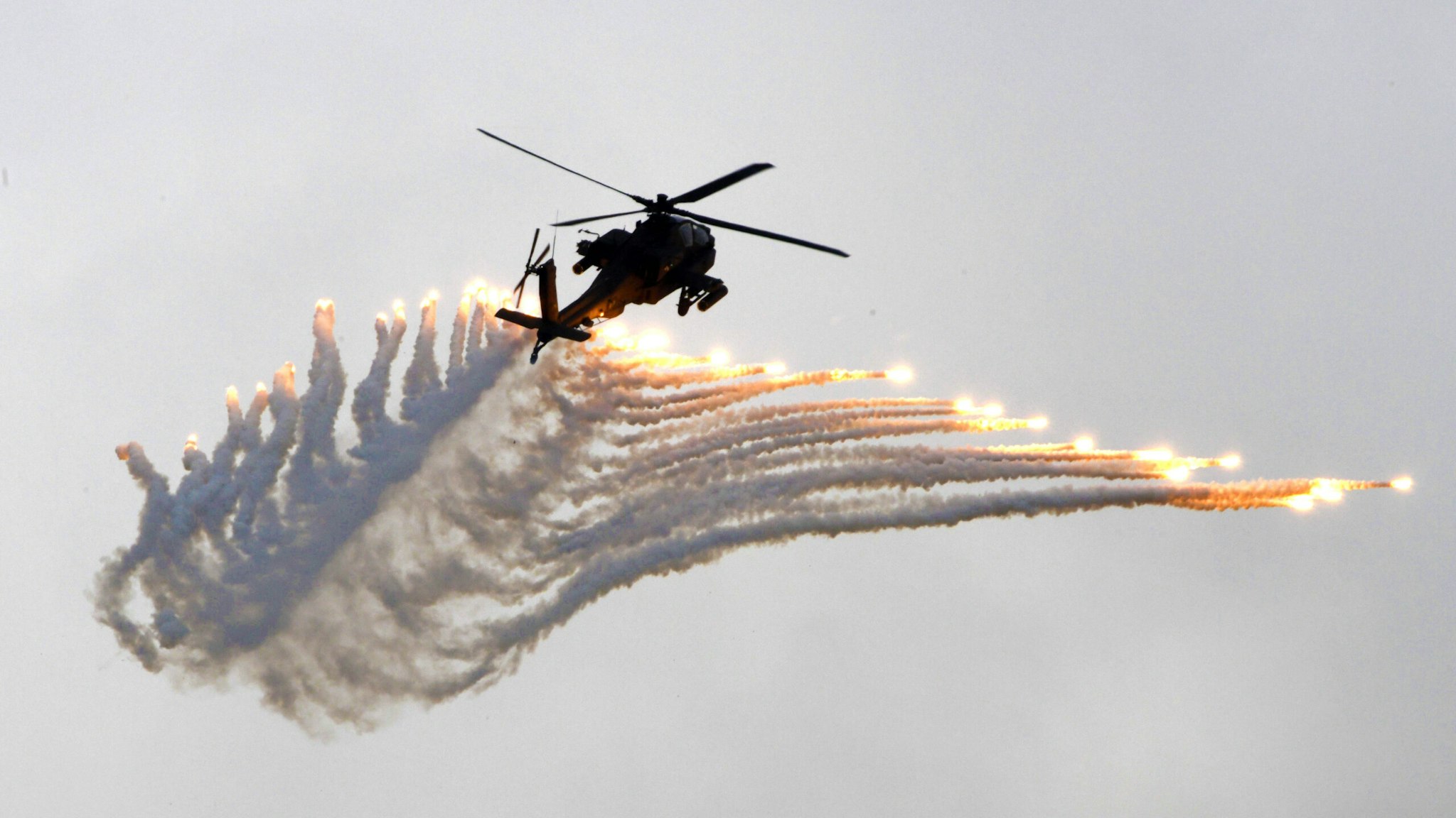 An AH-64 Apache attack helicopter releases flares during the Han Kuang drill at the Ching Chuan Kang (CCK) air force base in Taichung, central Taiwan, on June 7, 2018. - Taiwan on June 7 staged its largest annual drills simulating Chinese attacks as Beijing stepped up military and diplomatic pressure on the island amid growing tensions.