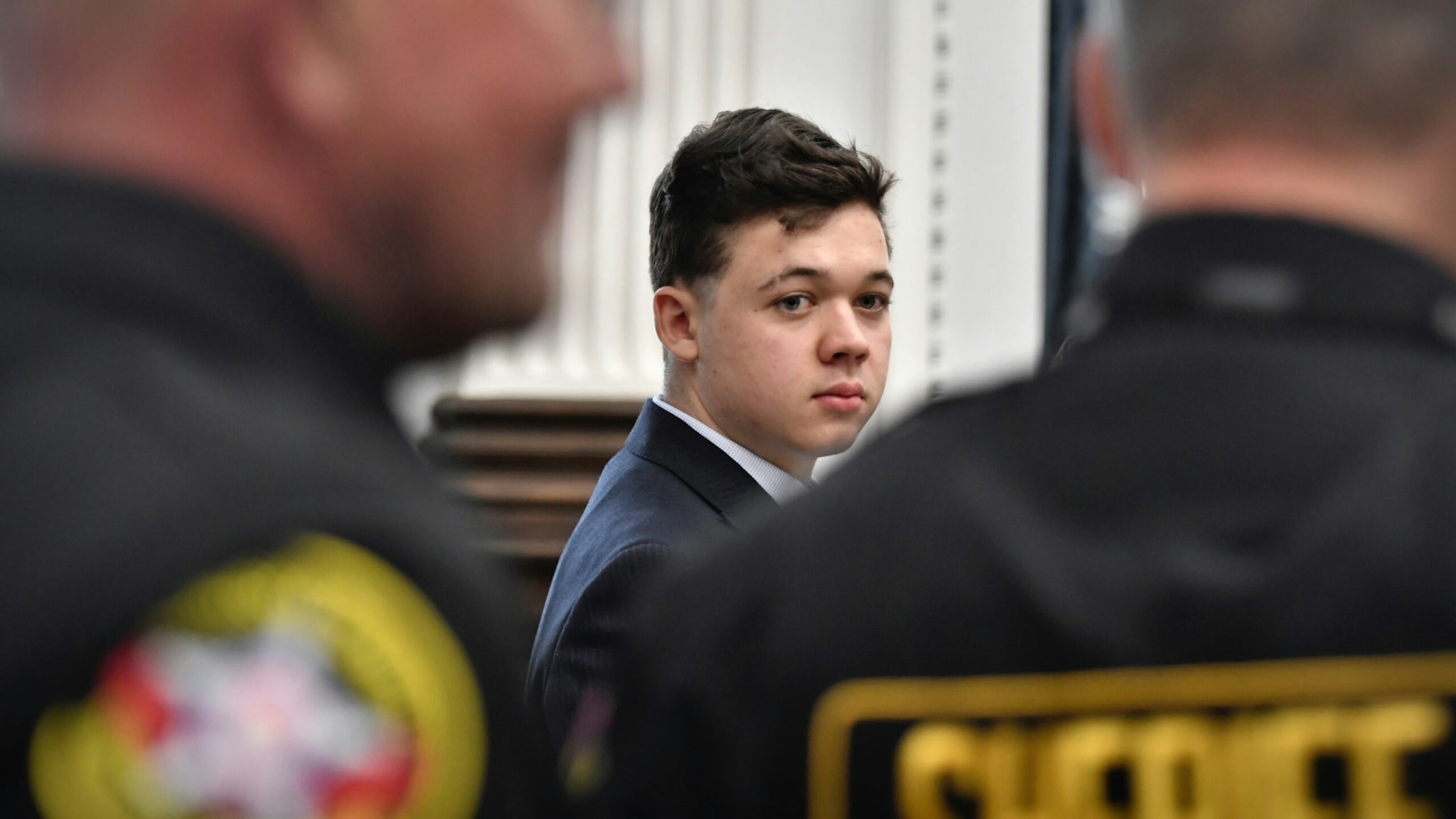 Kyle Rittenhouse, center, looks back as Kenosha County Sheriff's deputies enter the courtroom to escort him out of the room during a break in the trial at the Kenosha County Courthouse on November 5, 2021 in Kenosha, Wisconsin.