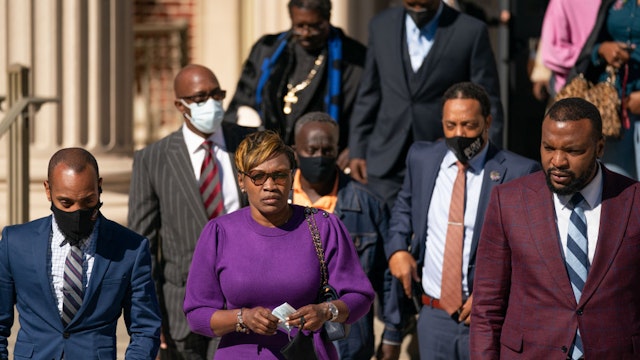 BRUNSWICK, GA - NOVEMBER 23: Wanda Cooper-Jones, mother of Ahmaud Arbery, center, leaves the Glynn County Courthouse with attorney Lee Merritt, right, as jury deliberations begin in the trial for the killers of her son on November 23, 2021 in Brunswick, Georgia. Greg McMichael, his son Travis McMichael, and a neighbor, William "Roddie" Bryan are charged with the February, 2020 fatal shooting of 25-year-old Ahmaud Arbery.