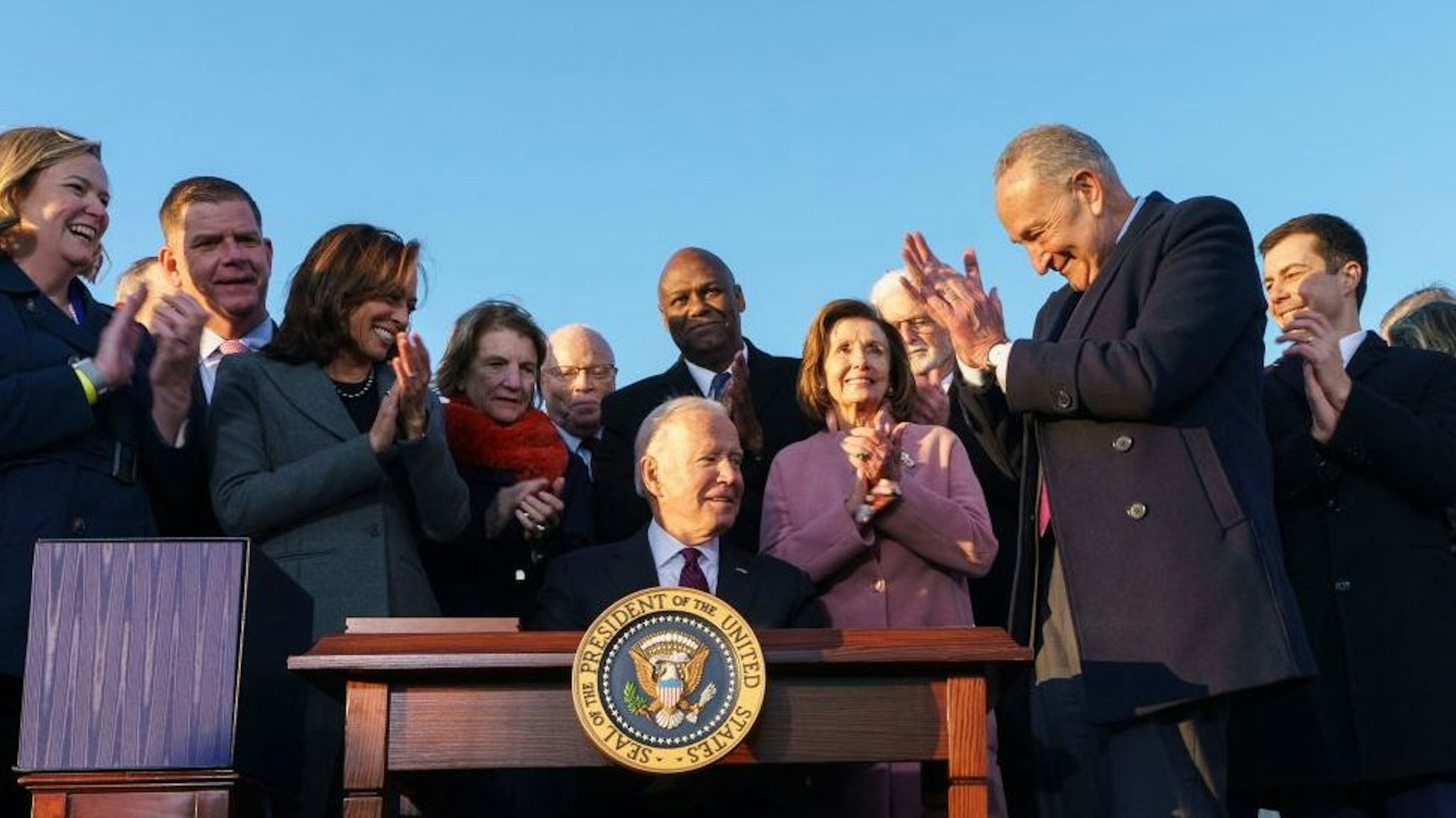 US President Joe Biden (C), flanked by Vice President Kamala Harris, takes part in a signing ceremony for H.R. 3684, the Infrastructure Investment and Jobs Act on the South Lawn of the White House in Washington, DC on November 15, 2021.