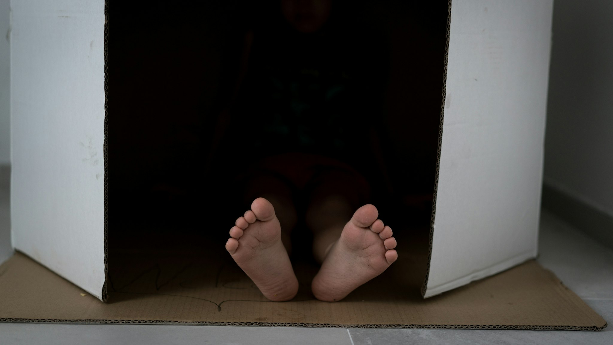 Child feet in carton box - stock photo