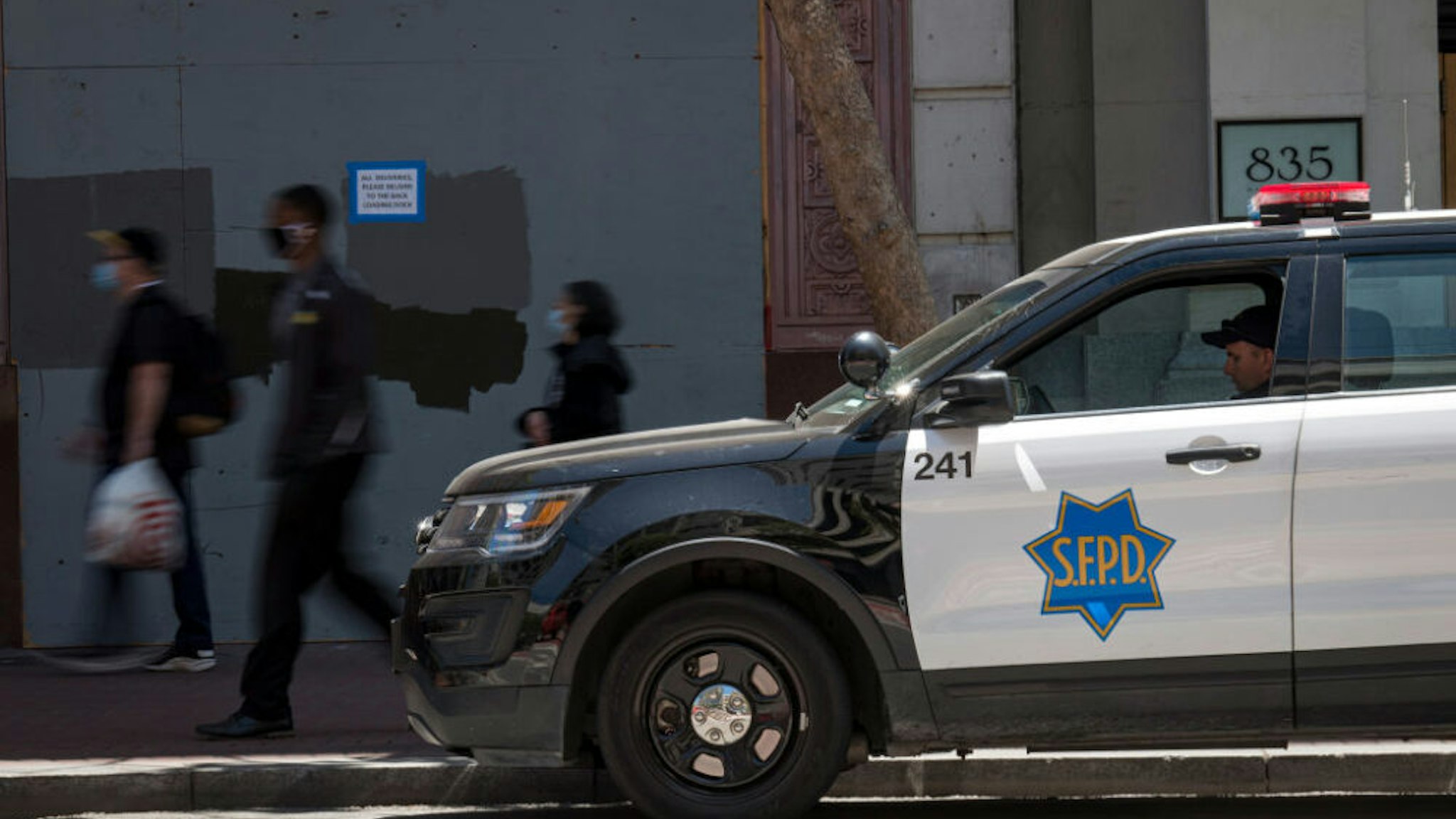A City of San Francisco police officer sits in a patrol vehicle on Market Street in San Francisco, California, U.S., on Tuesday, June 16, 2020. San Francisco police will stop responding to neighbor disputes, reports on homeless people, school discipline interventions and other non-criminal activities as part of a police reform plan the mayor announced Thursday.