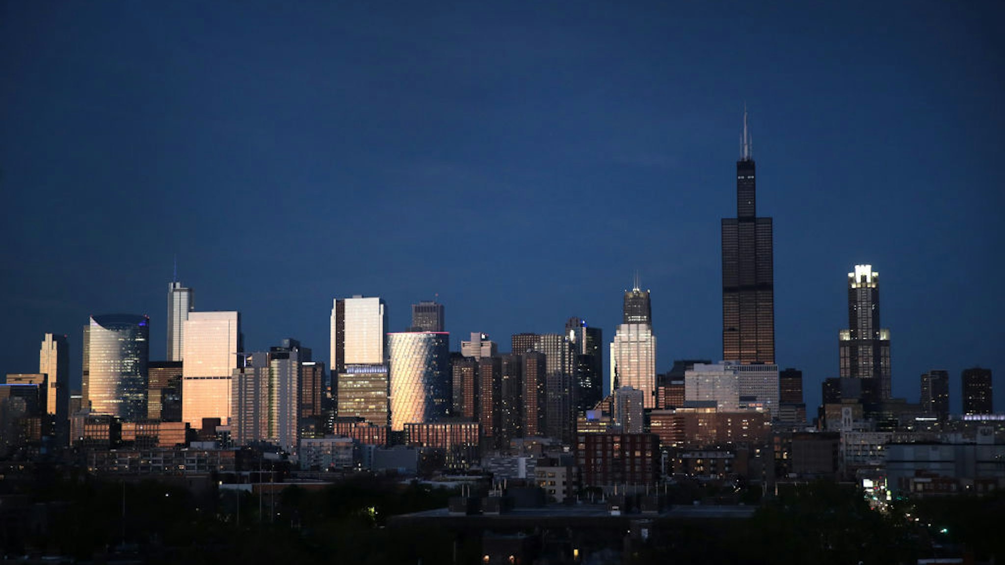 The Willis Tower rises above the downtown skyline as a blackened mass after flooding caused by recent heavy rains knocked out power to the building Monday on May 20, 2020 in Chicago, Illinois.