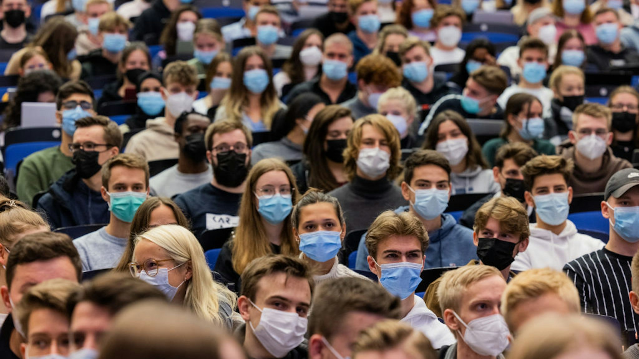 11 October 2021, North Rhine-Westphalia, Münster: Students wear mouth-to-nose coverings while sitting close to each other during the lecture "BWL 1" in lecture hall H1 of the Westfälische Wilhelms-Universität (WWU). For the first time since the beginning of the Corona pandemic, lectures in the winter semester 21/22 have started in presence under 3G conditions. Photo: Rolf Vennenbernd/dpa (Photo by Rolf Vennenbernd/picture alliance via Getty Images)