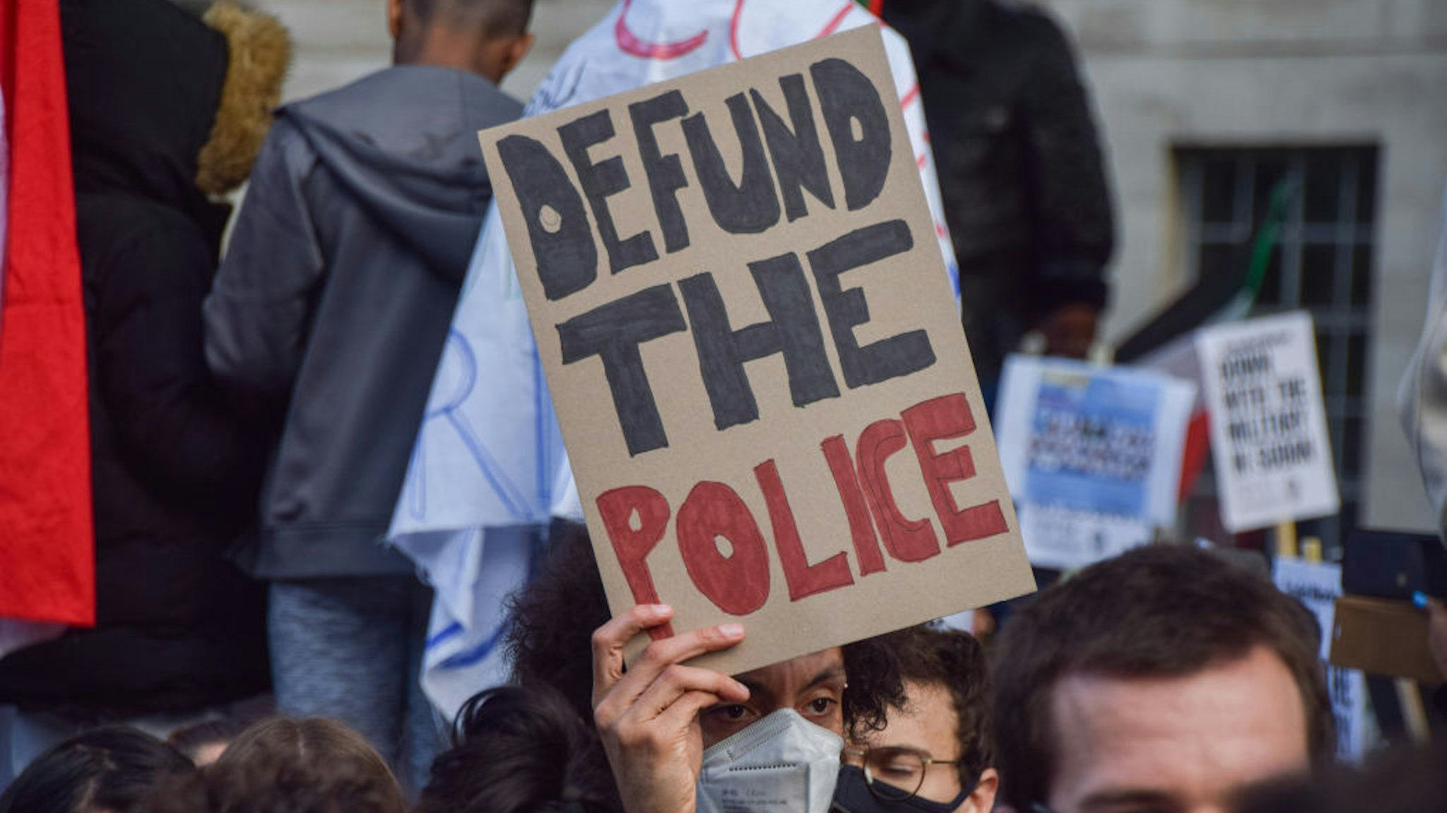 A protester holds a 'Defund The Police' placard during the demonstration outside Downing Street.
