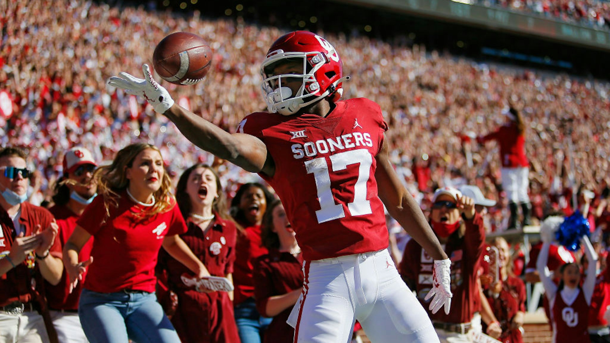 NORMAN, OK - OCTOBER 30: Wide receiver Marvin Mims #17 of the Oklahoma Sooners pops and rolls the ball off his fingertips after scoring on a 67-yard catch and run for a touchdown against the Texas Tech Red Raiders in the first quarter at Gaylord Family Oklahoma Memorial Stadium on October 30, 2021 in Norman, Oklahoma. Oklahoma won 52-21. (Photo by Brian Bahr/Getty Images)