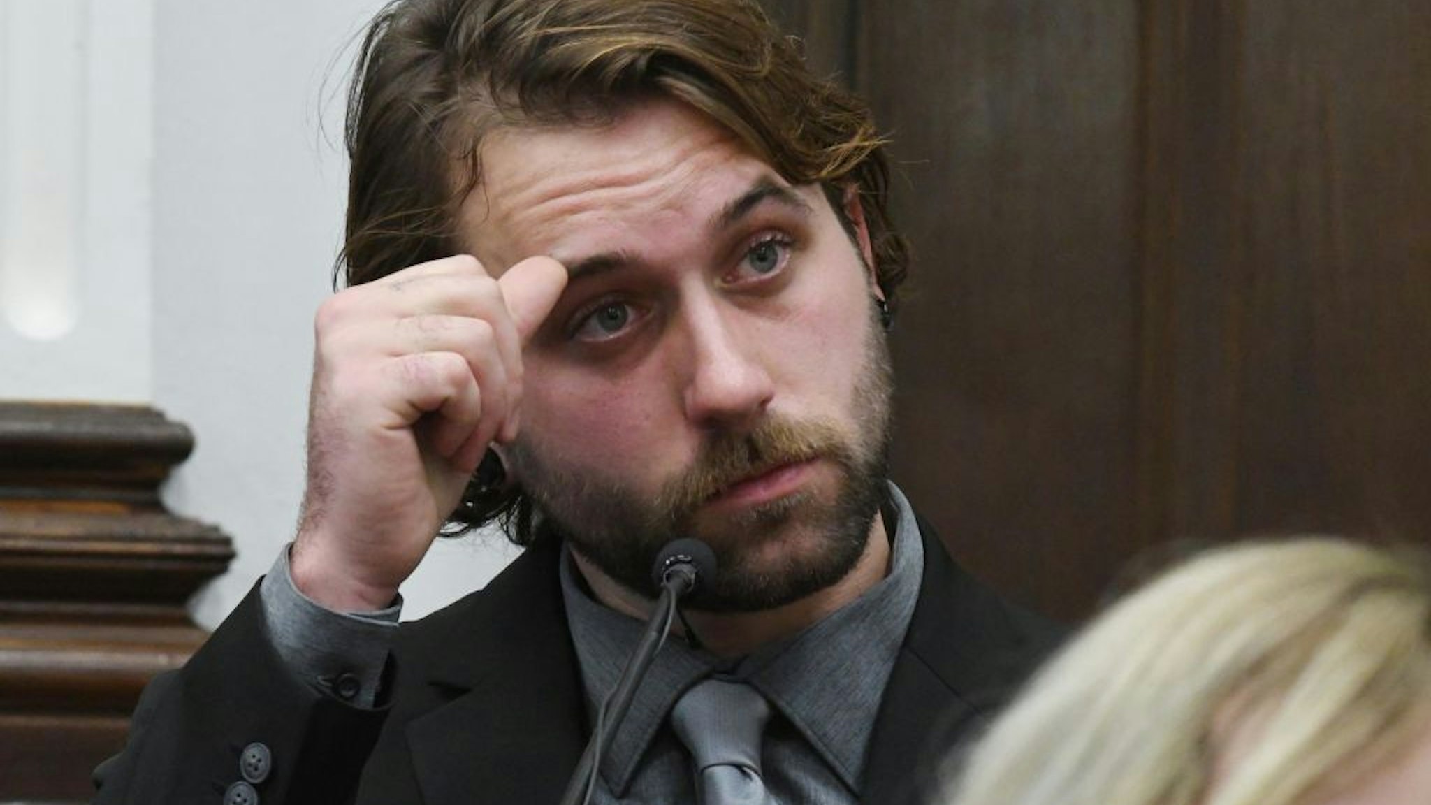 aige Grosskreutz watches video as he testifies about being shot in the right arm during the Kyle Rittenhouse trial at the Kenosha County Courthouse on November 8, 2021 in Kenosha, Wisconsin.