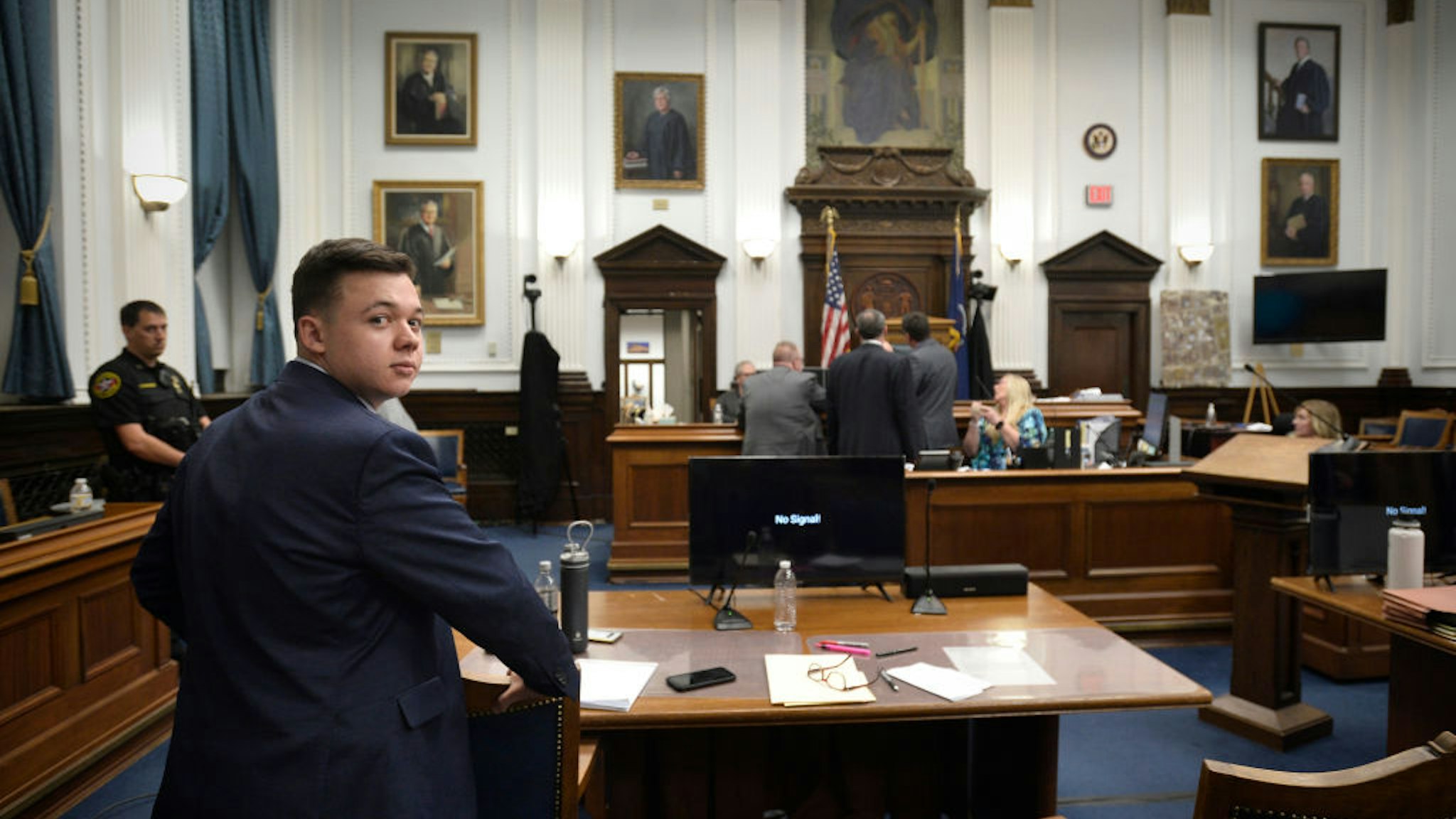 Kyle Rittenhouse waits at his table as his attorneys speak with Judge Bruce Schroeder at the end of the day's proceedings in Rittenhouse's trial at the Kenosha County Courthouse on November 8, 2021 in Kenosha, Wisconsin.