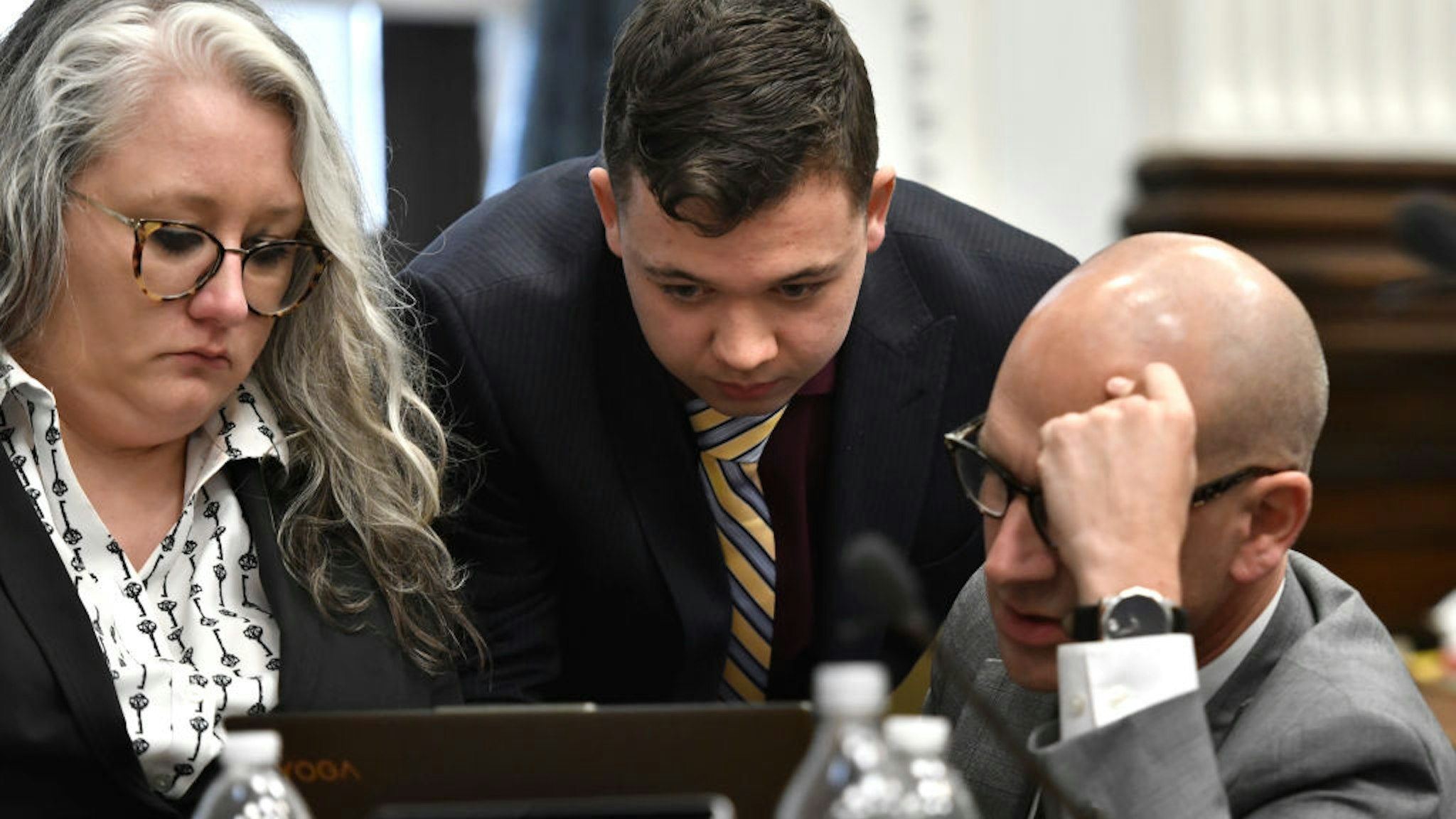 Kyle Rittenhouse, center, and his attorneys Natalie Wisco, left, and Corey Chirafisi look closely at a computer screen during his trial at the Kenosha County Courthouse on November 11, 2021 in Kenosha, Wisconsin.