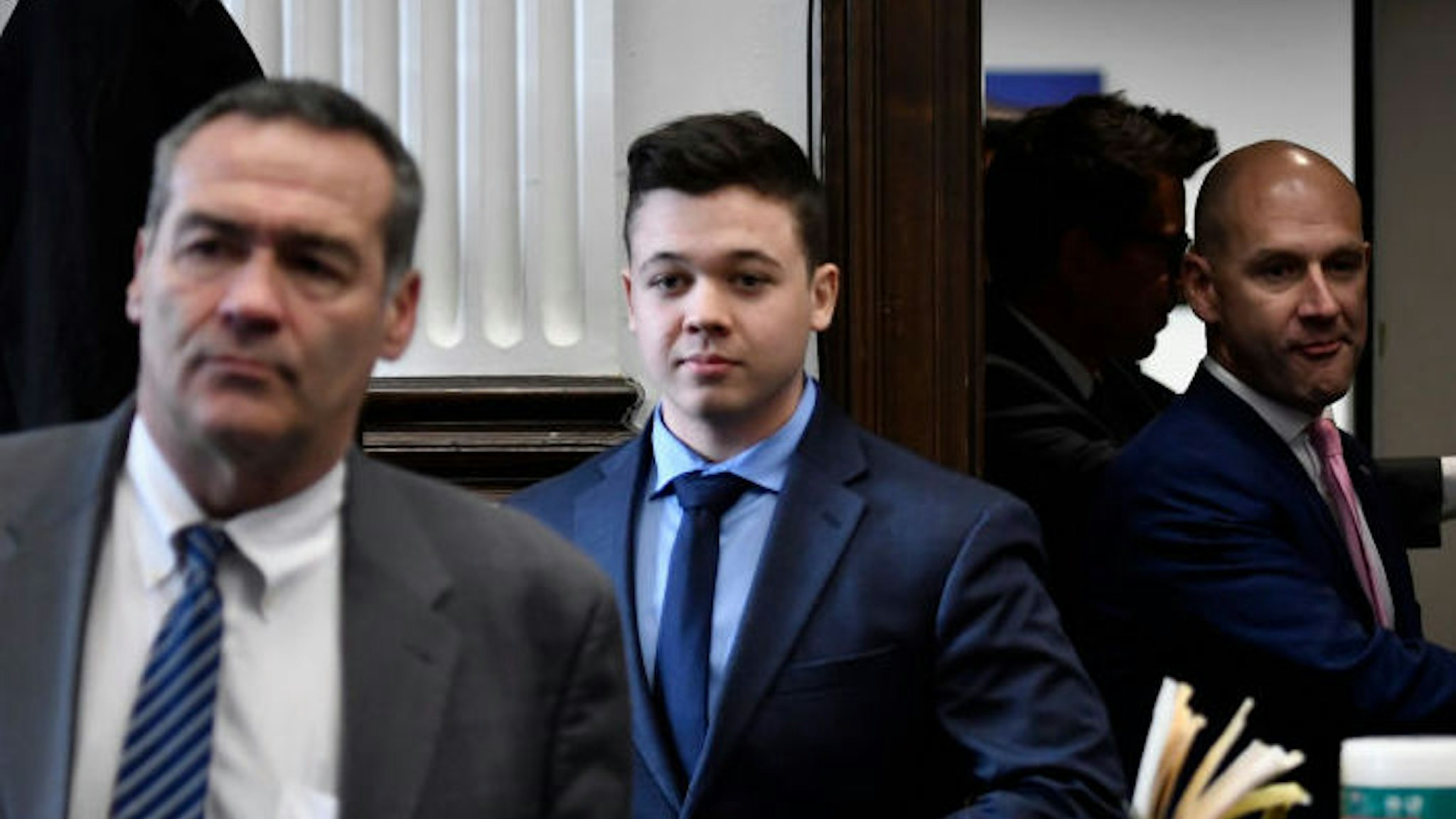 Kyle Rittenhouse, center, enters the courtroom with his attorneys Mark Richards, left, and Corey Chirafisi for a meeting called by Judge Bruce Schroeder at the Kenosha County Courthouse on November 18, 2021 in Kenosha, Wisconsin.