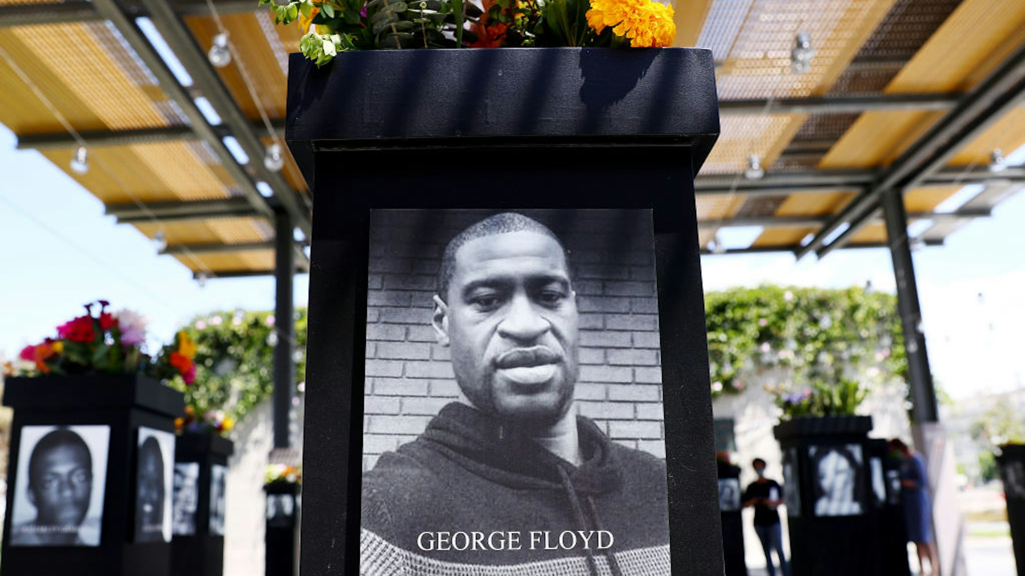 A photograph of George Floyd (C) is displayed along with other photographs at the Say Their Names memorial exhibit at Martin Luther King Jr. Promenade on July 20, 2021 in San Diego, California.